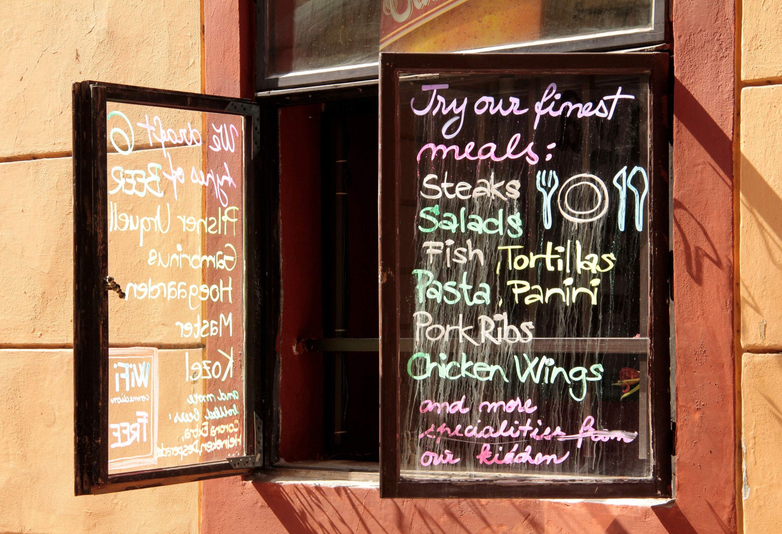 A restaurant window displaying a written menu.