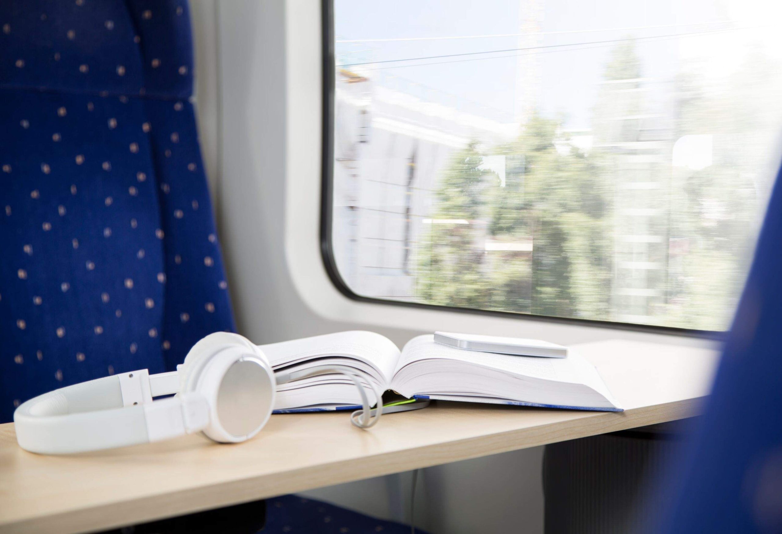 a book and a headphone on a table inside a train