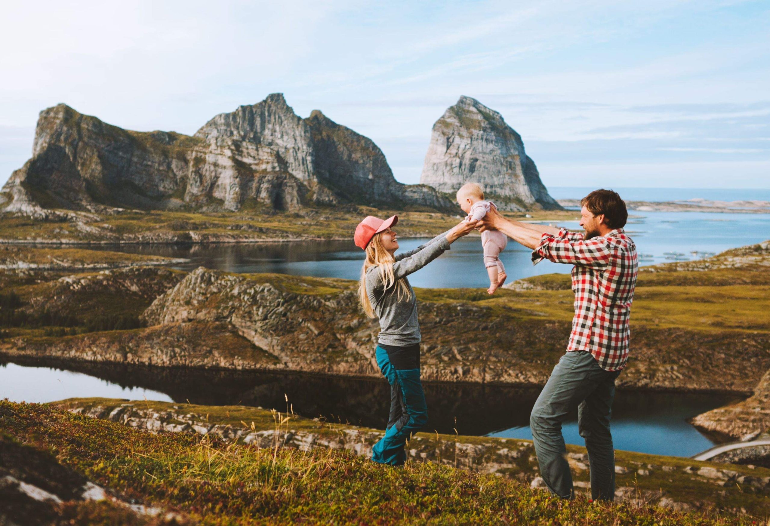 Family couple mother and father with baby travel vacations outdoor man and woman with kid healthy lifestyle trip in Norway Helgeland islands happy emotions