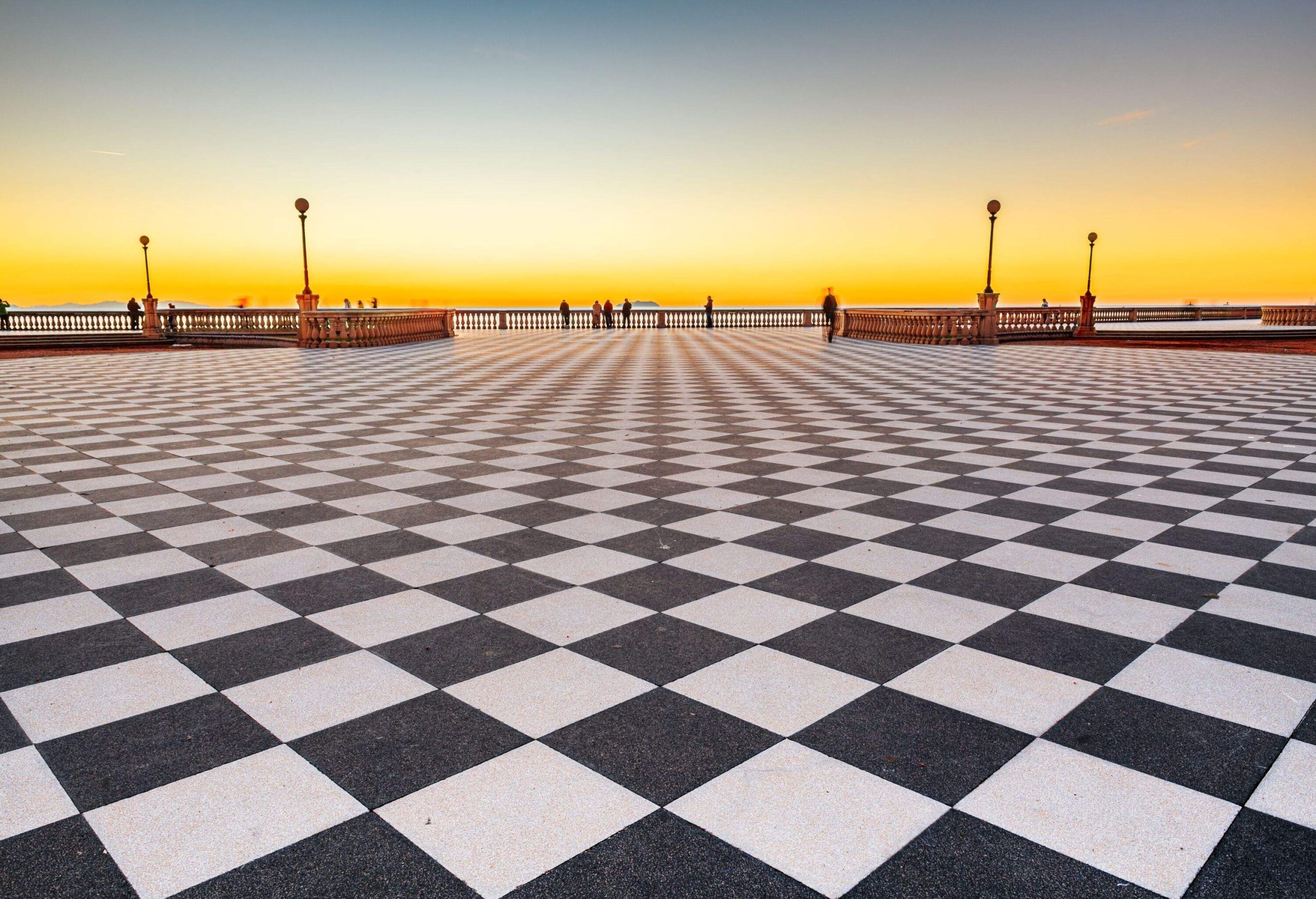 a black and white checked pathway at sunset