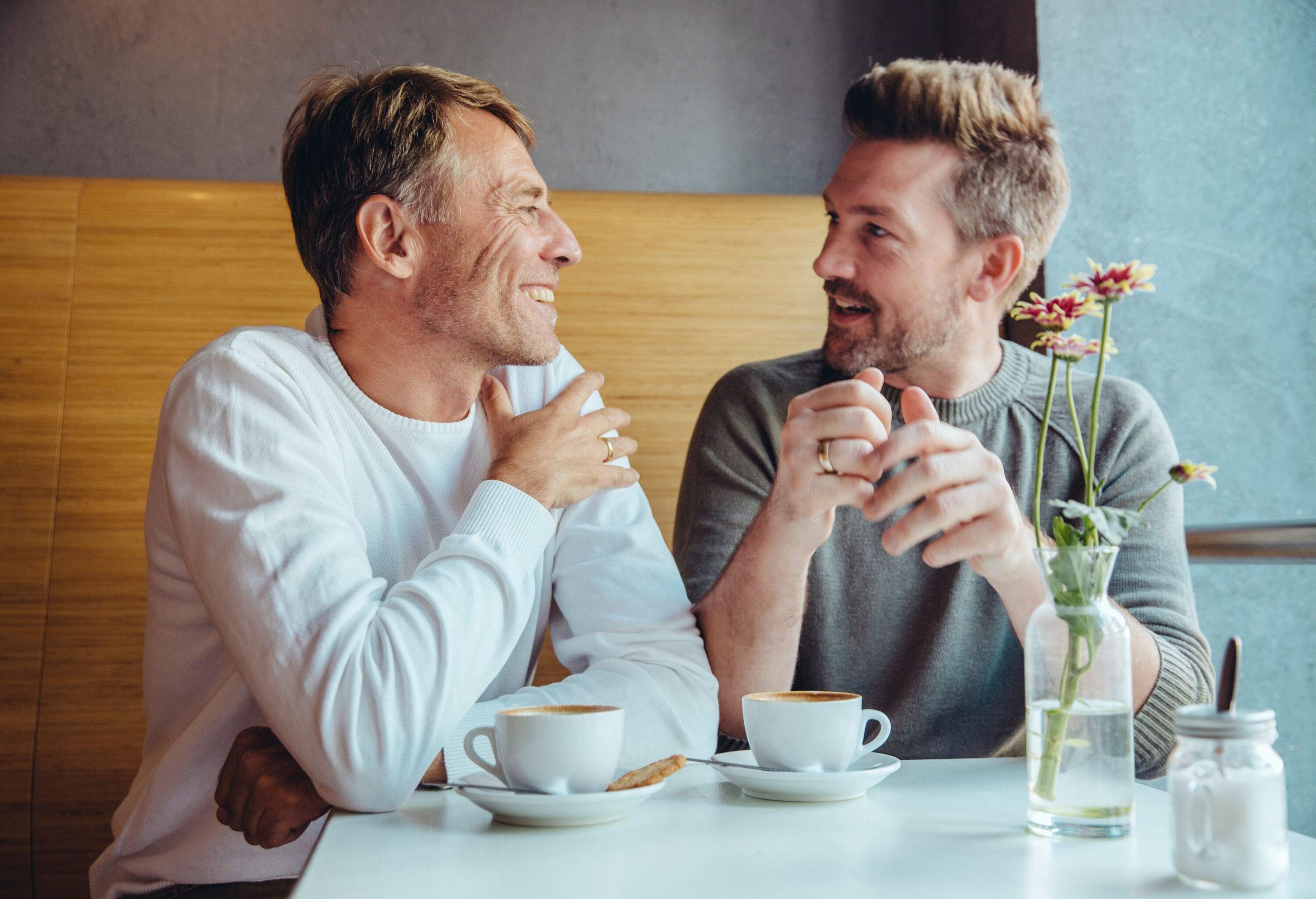 Two men having coffee and chatting with each other.