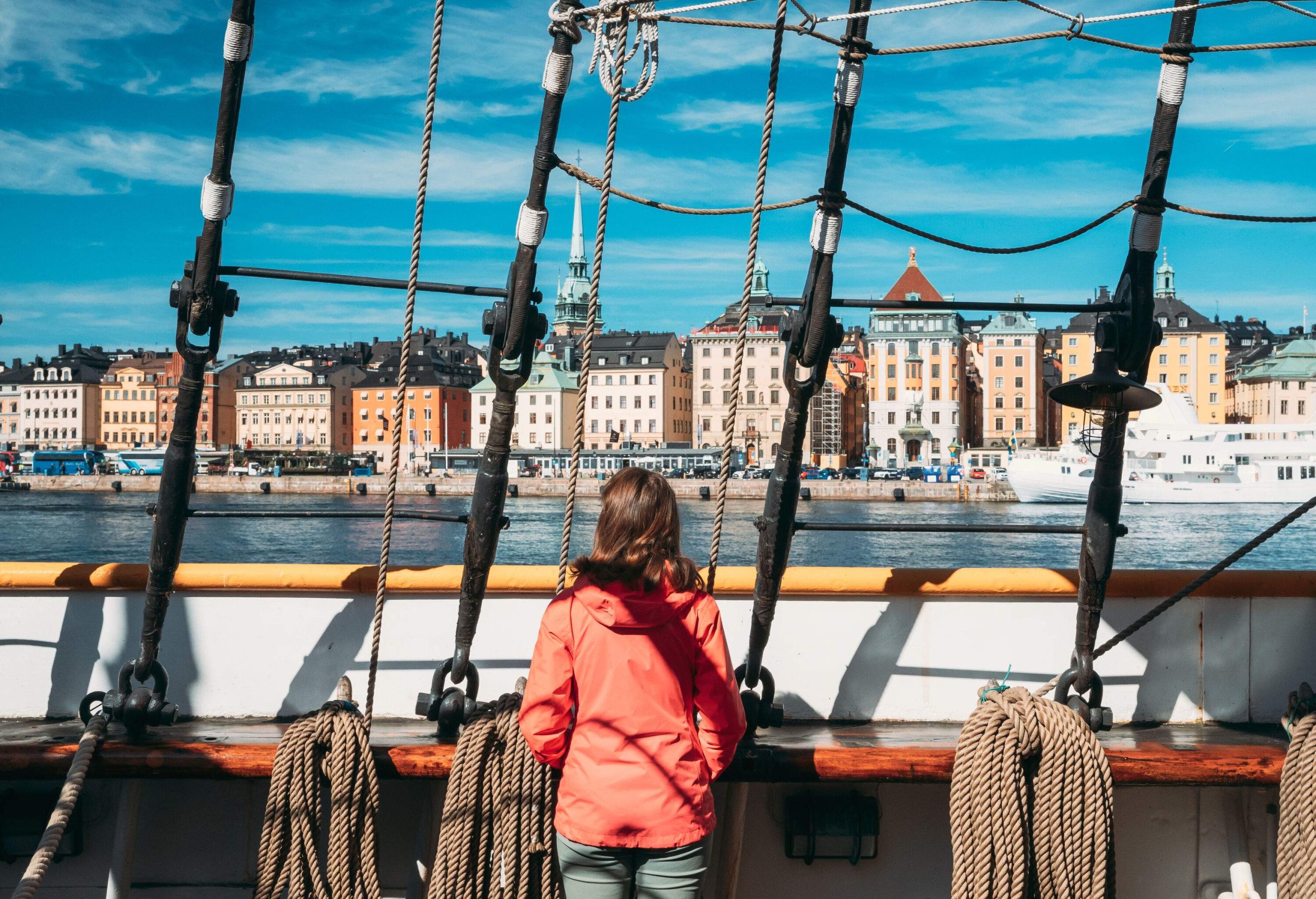 A person looks at the rows of classic and elegant buildings from a ship.