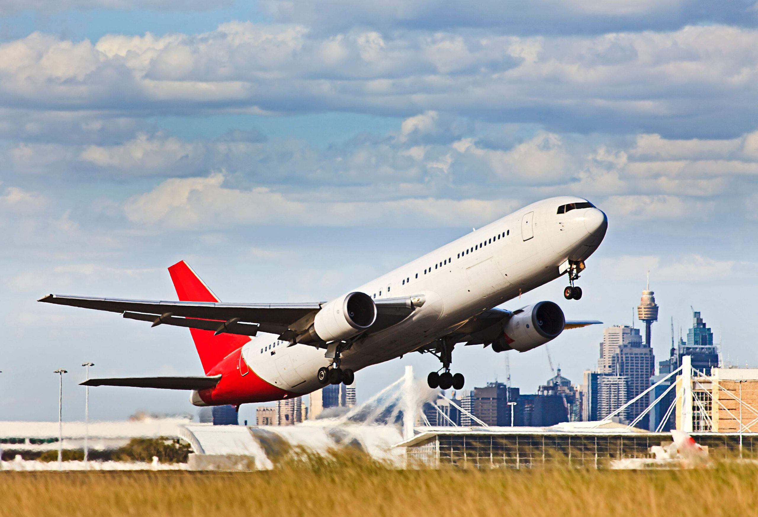 An airplane taking off from the ground and soars towards the sky.