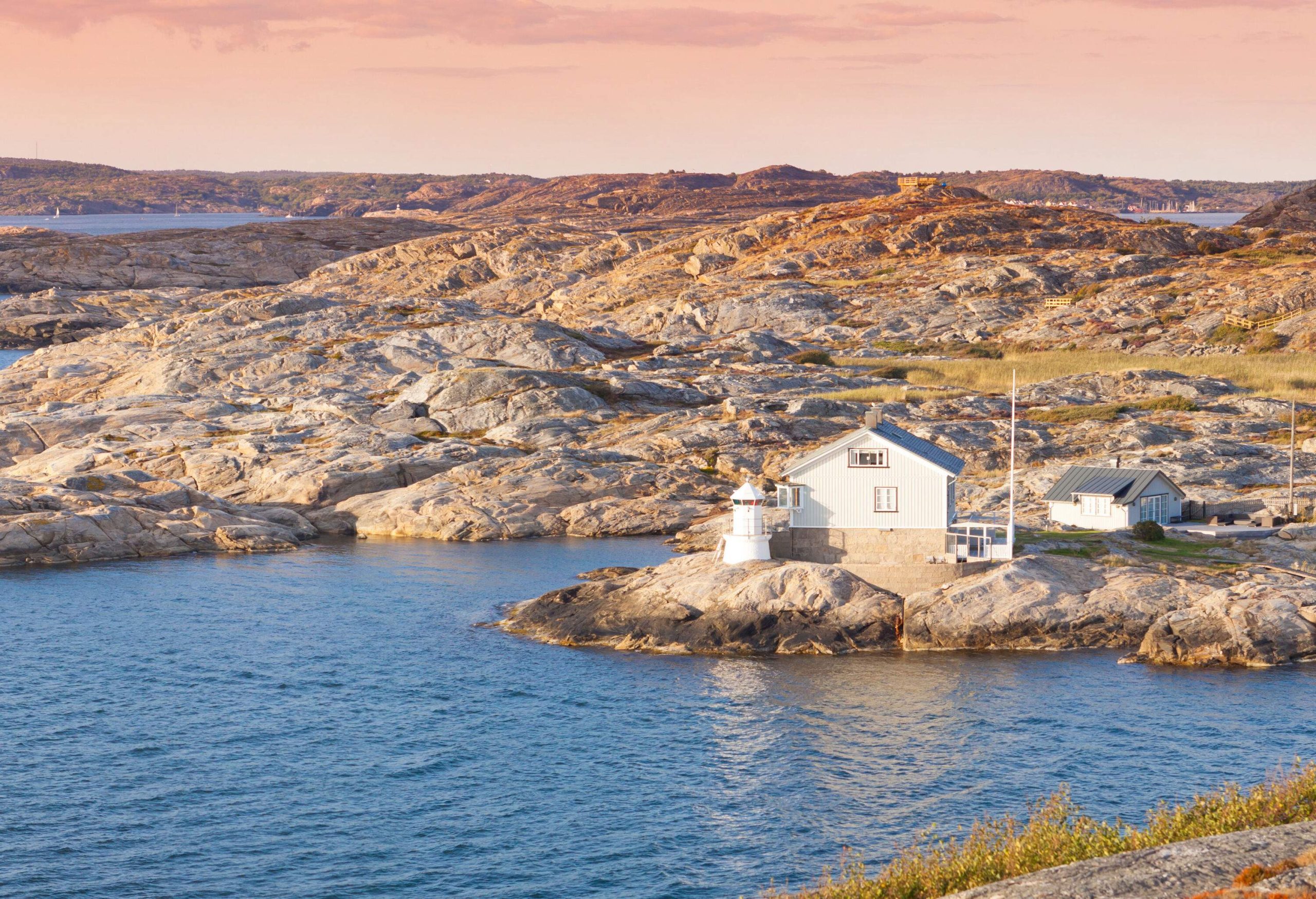 A lighthouse at the edge of a rocky coastline.