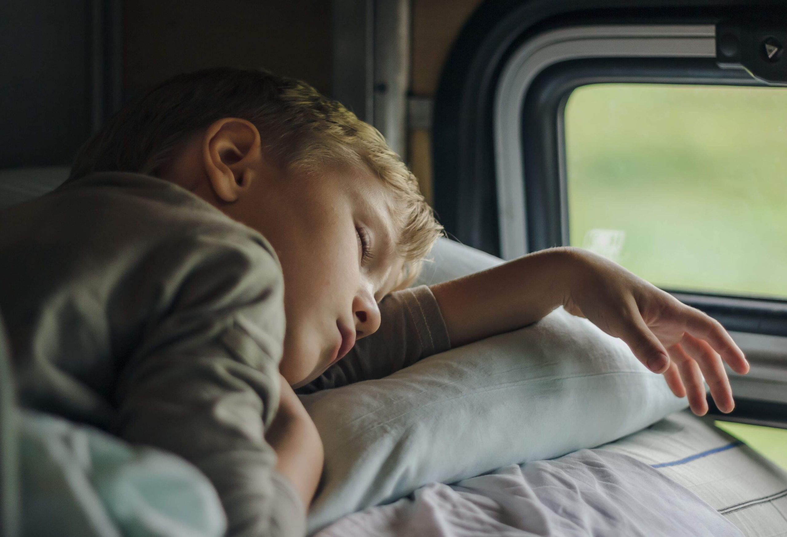 Sleeping boy in front of a train's window