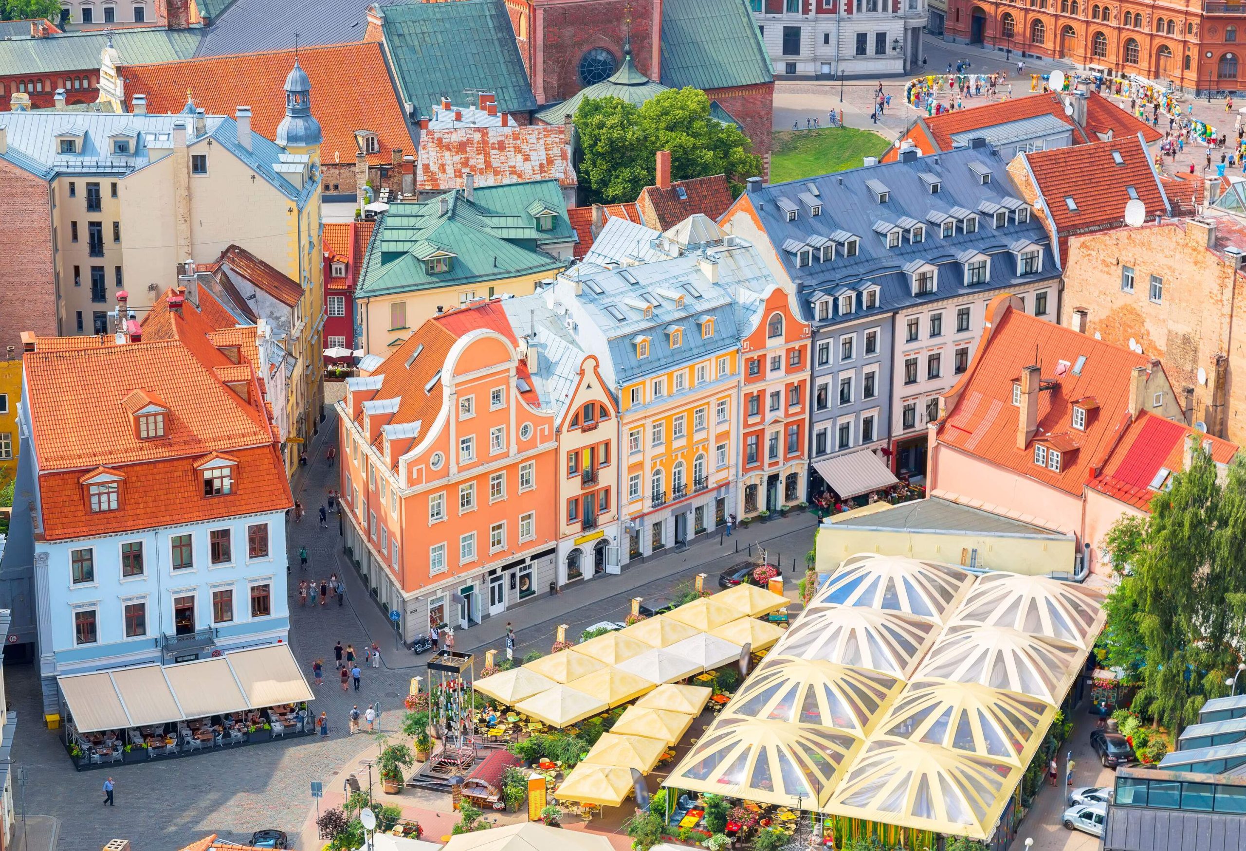 A vibrant market square with flower stands and vividly coloured buildings.