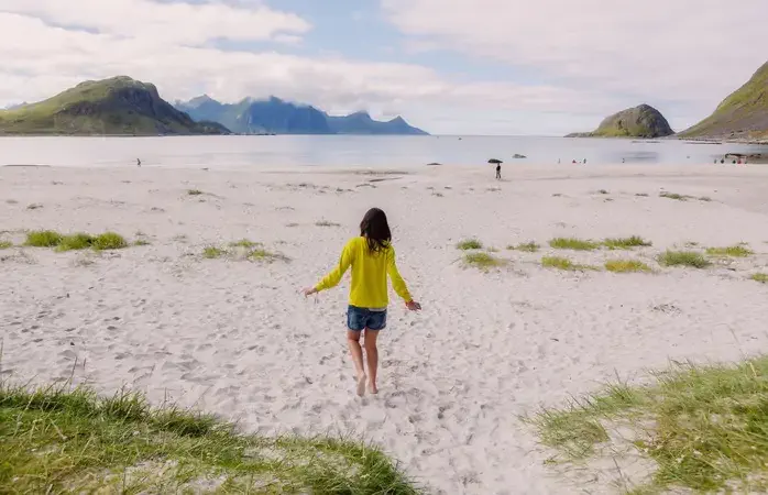 rear view of younf brunette walking in lofoten beach
