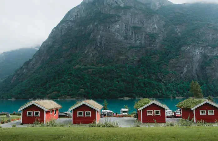 View of red houses with grass on the roof in camping site in South Norway