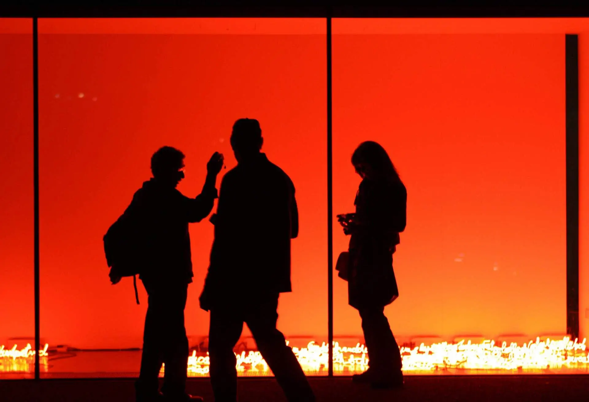 In red glow of an art installation outside Tate Modern, London.