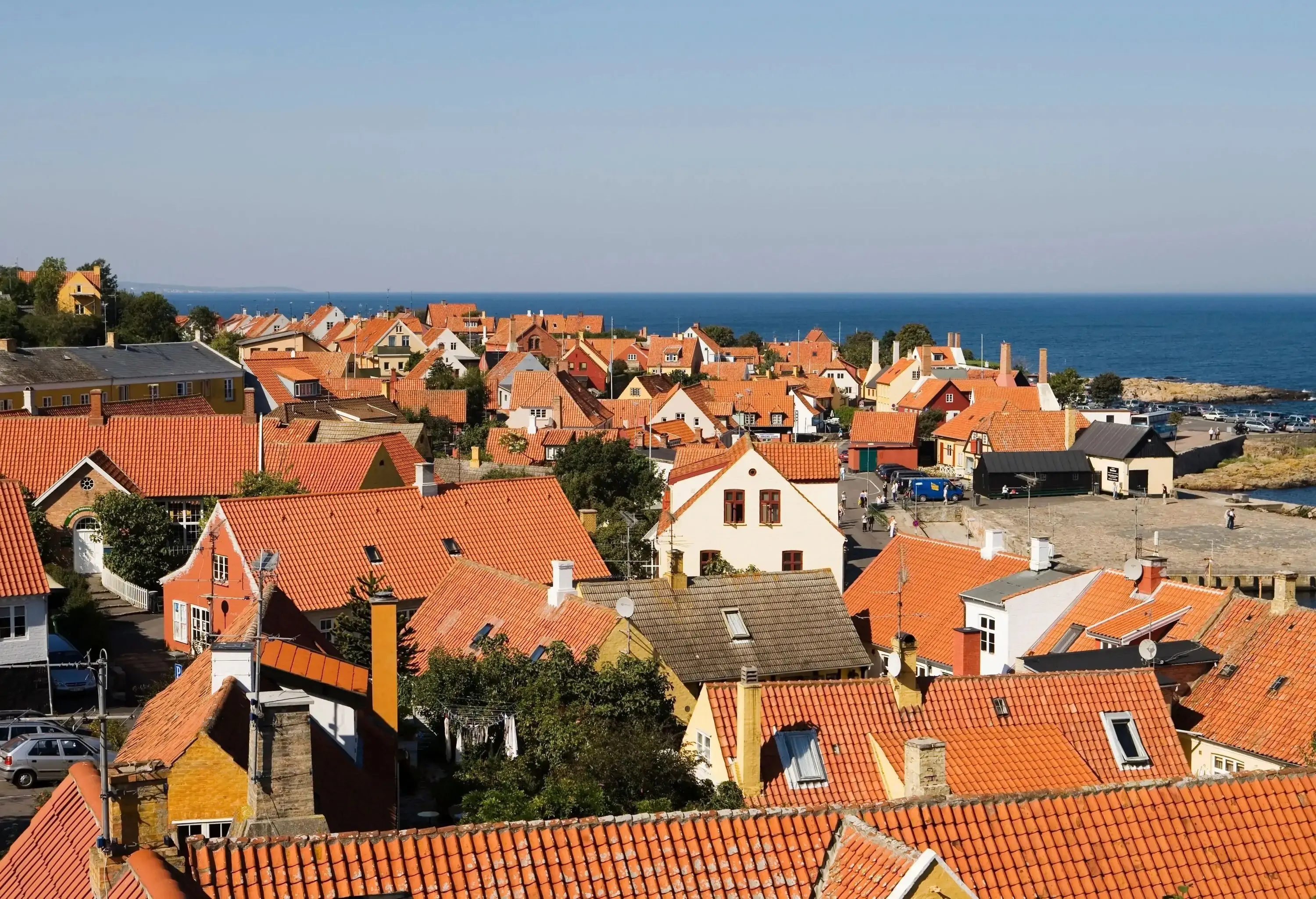 A coastal town with tiled rooftops and a plaza directly on the sea.