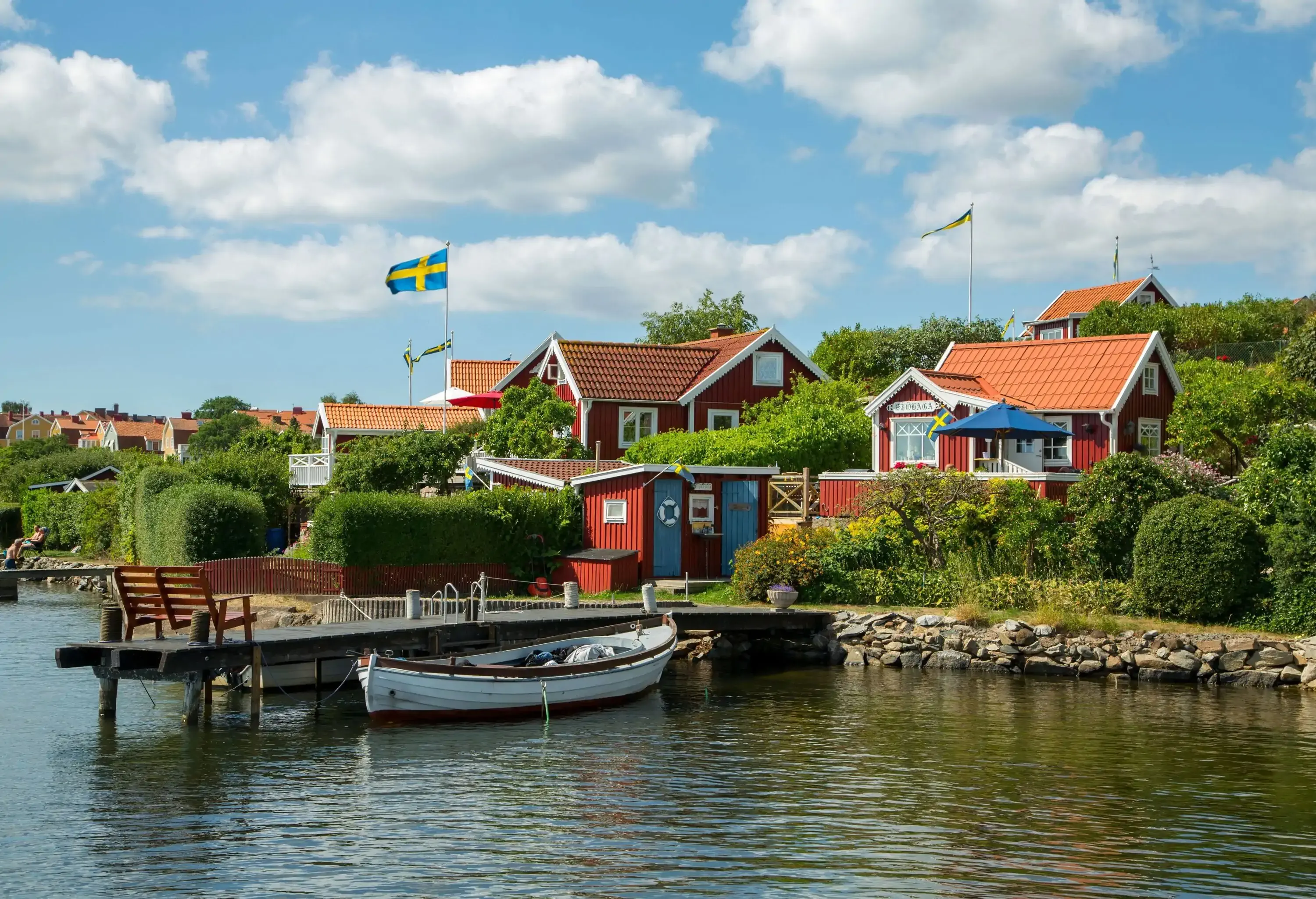 A seaside neighbourhood with Swedish flags flying over the houses.