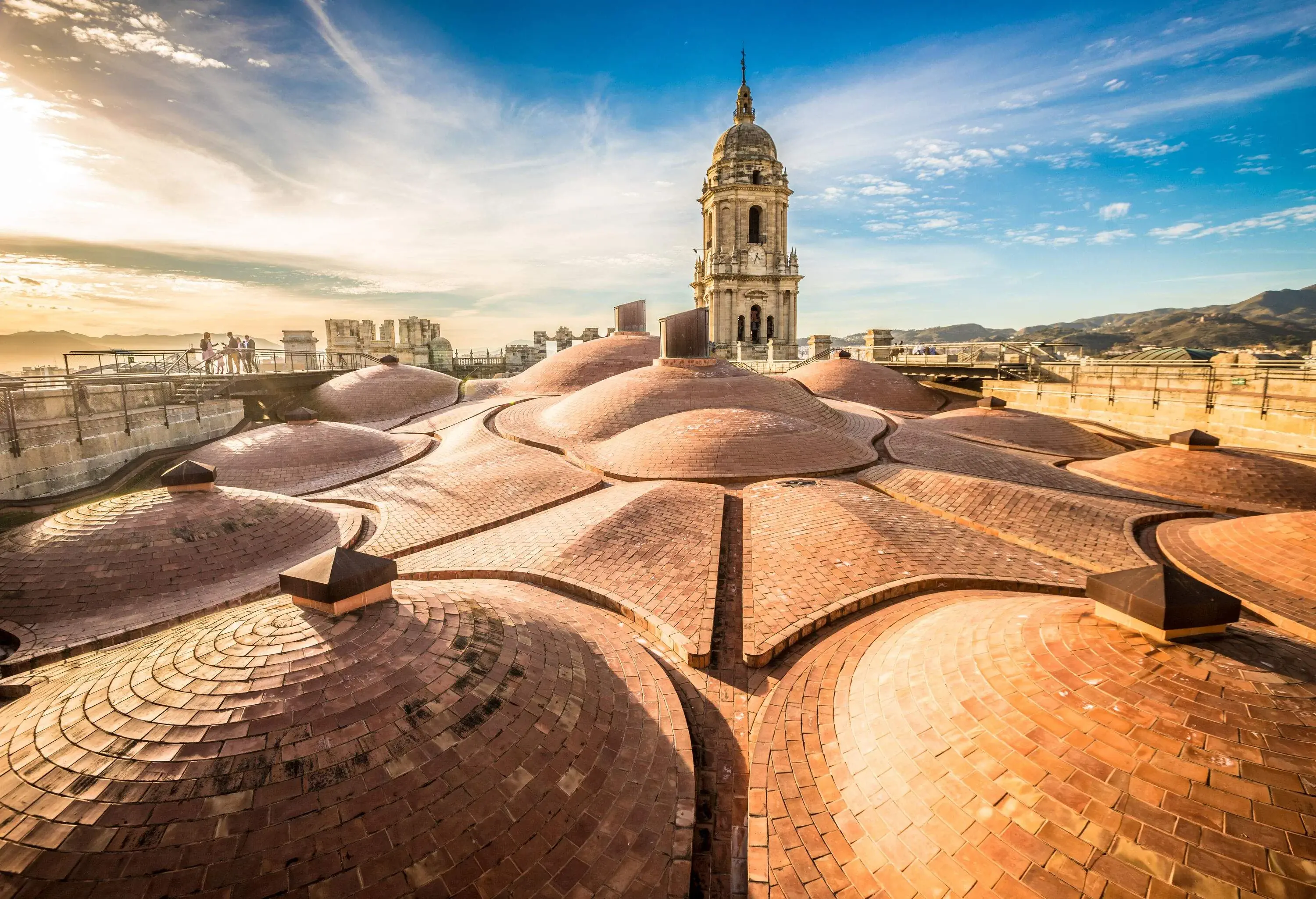 A unique spectacular sunlit church's rooftop made of multiple small hemispherical roofs with its protruding bell tower.