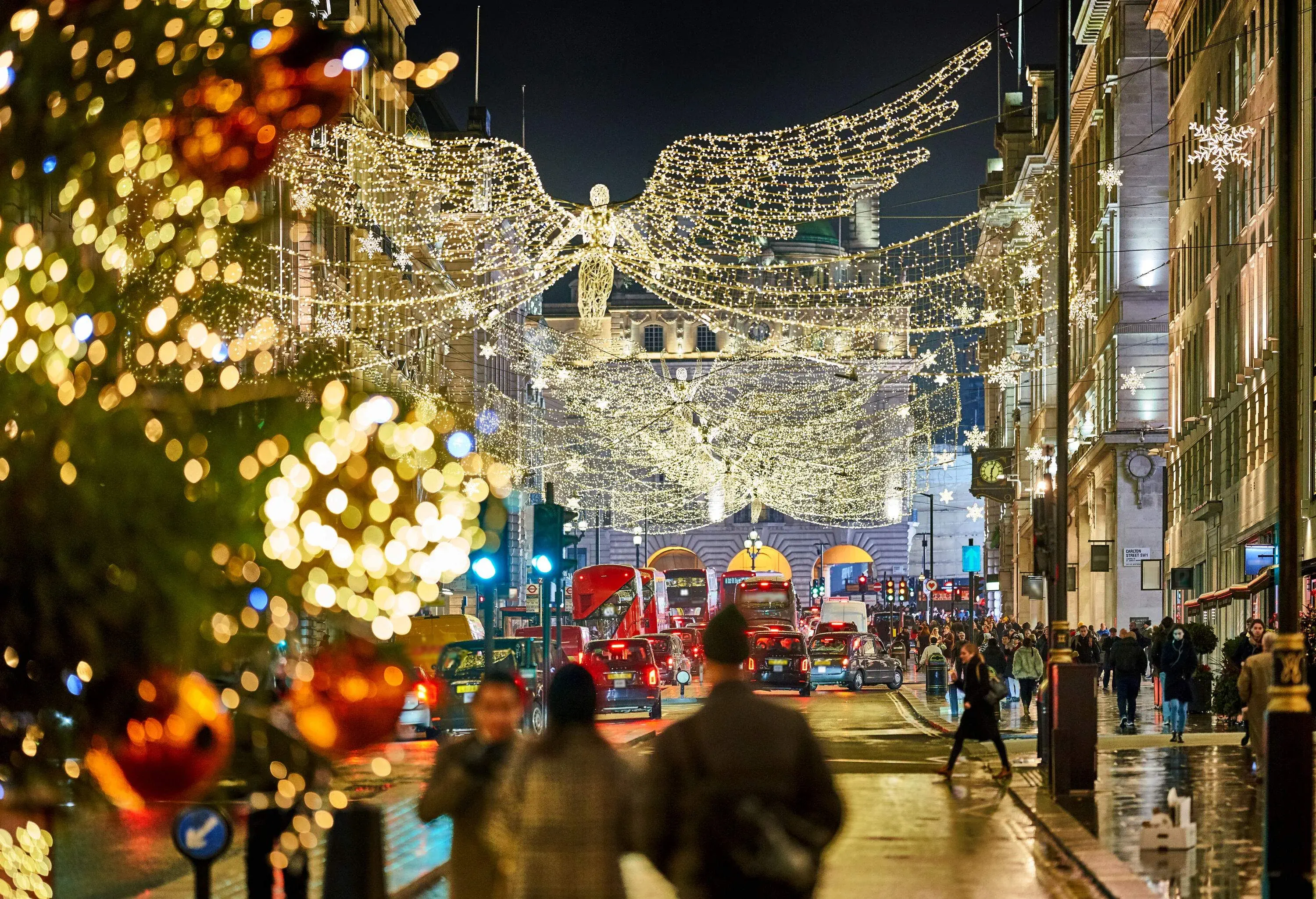 At night on a busy street a December evening, Christmas decorations hanging over boulevard
