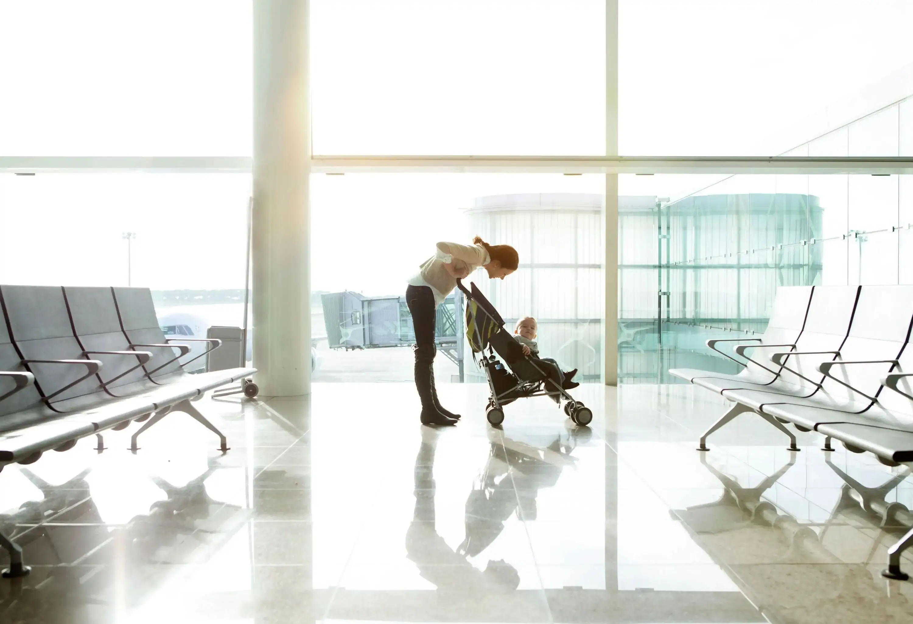 A mother with a child in a stroller at the airport