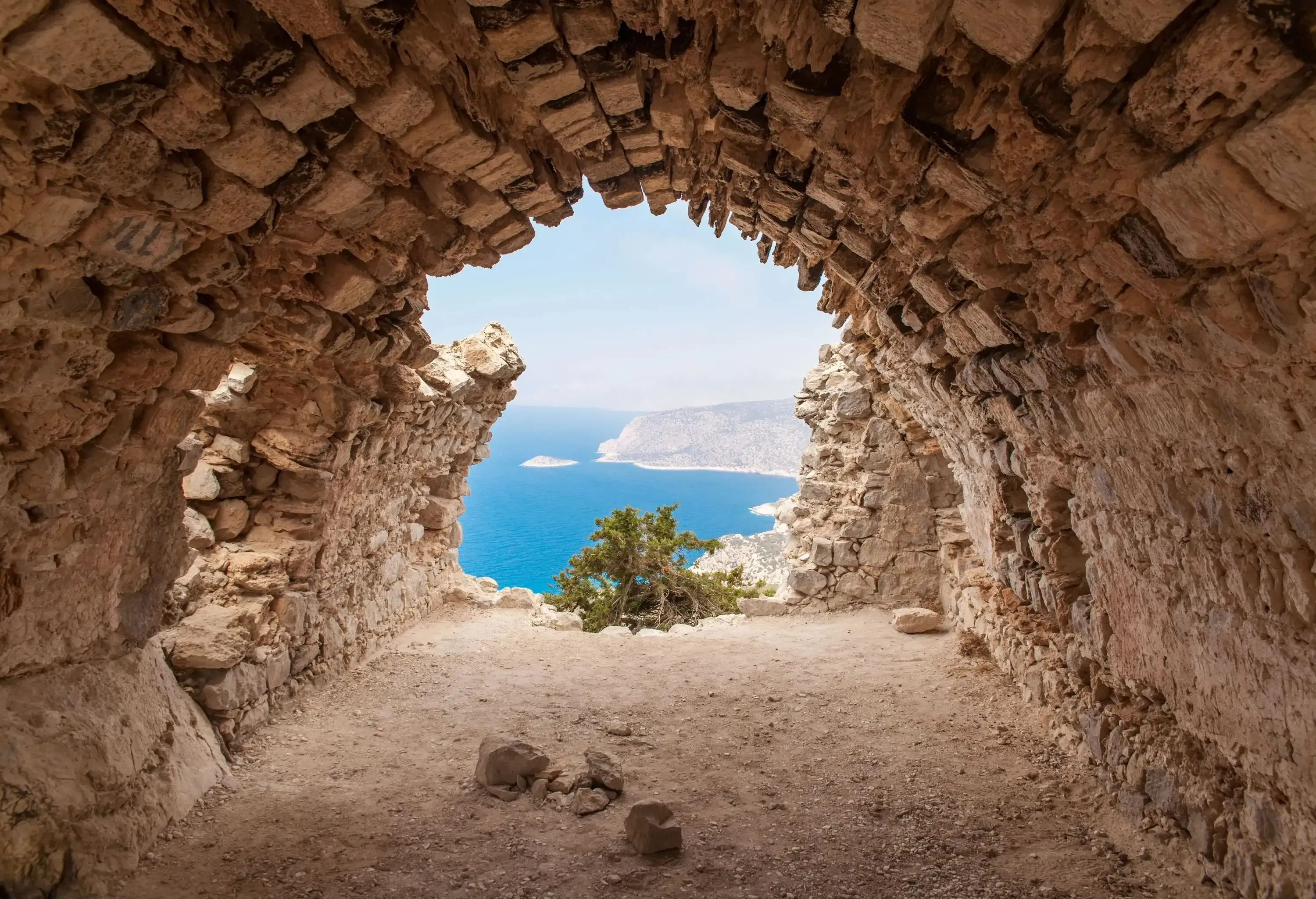Tranquil blue sea is seen from inside the remains of an ancient castle.