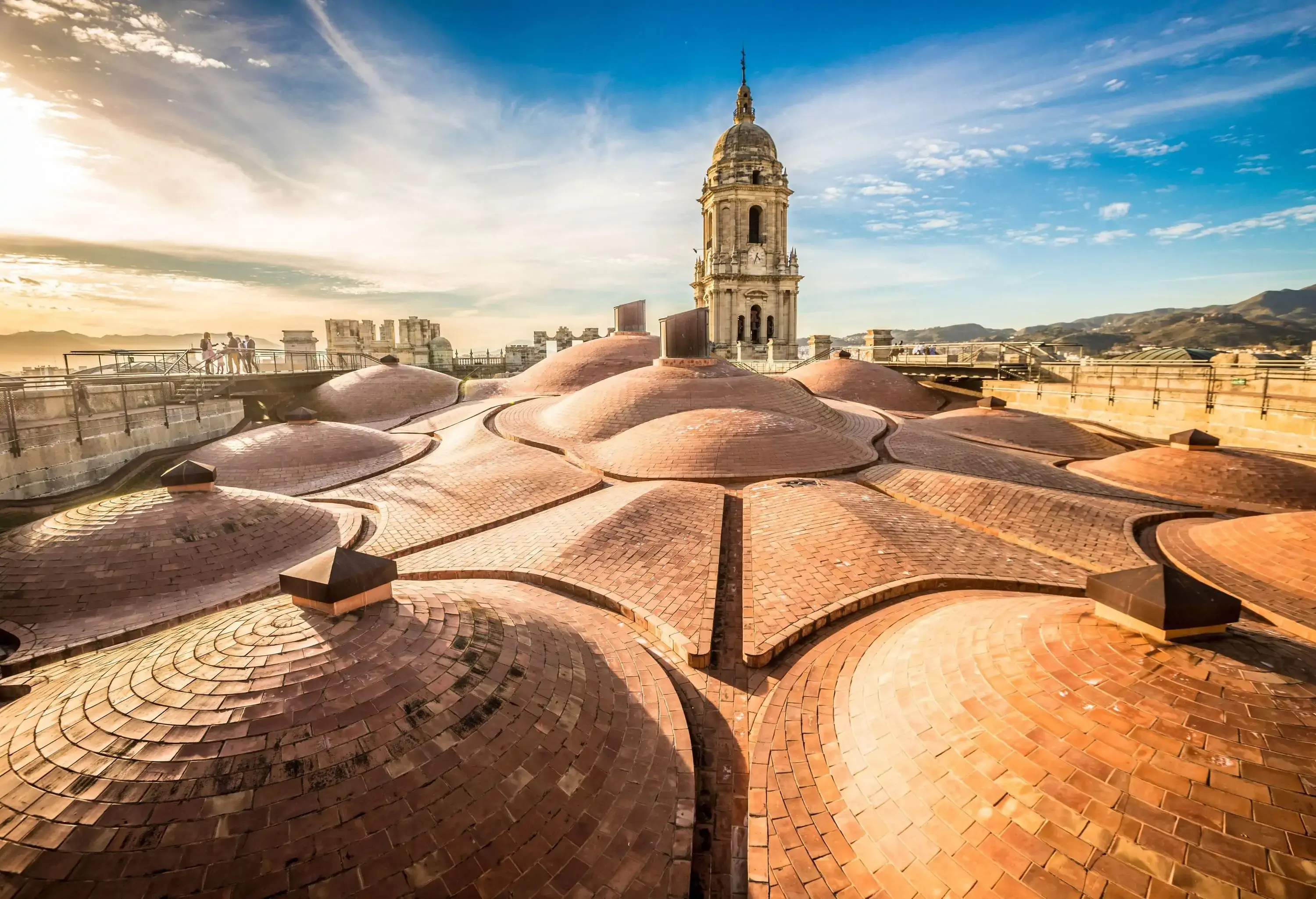 A unique spectacular sunlit church's rooftop made of multiple small hemispherical roofs with its protruding bell tower.