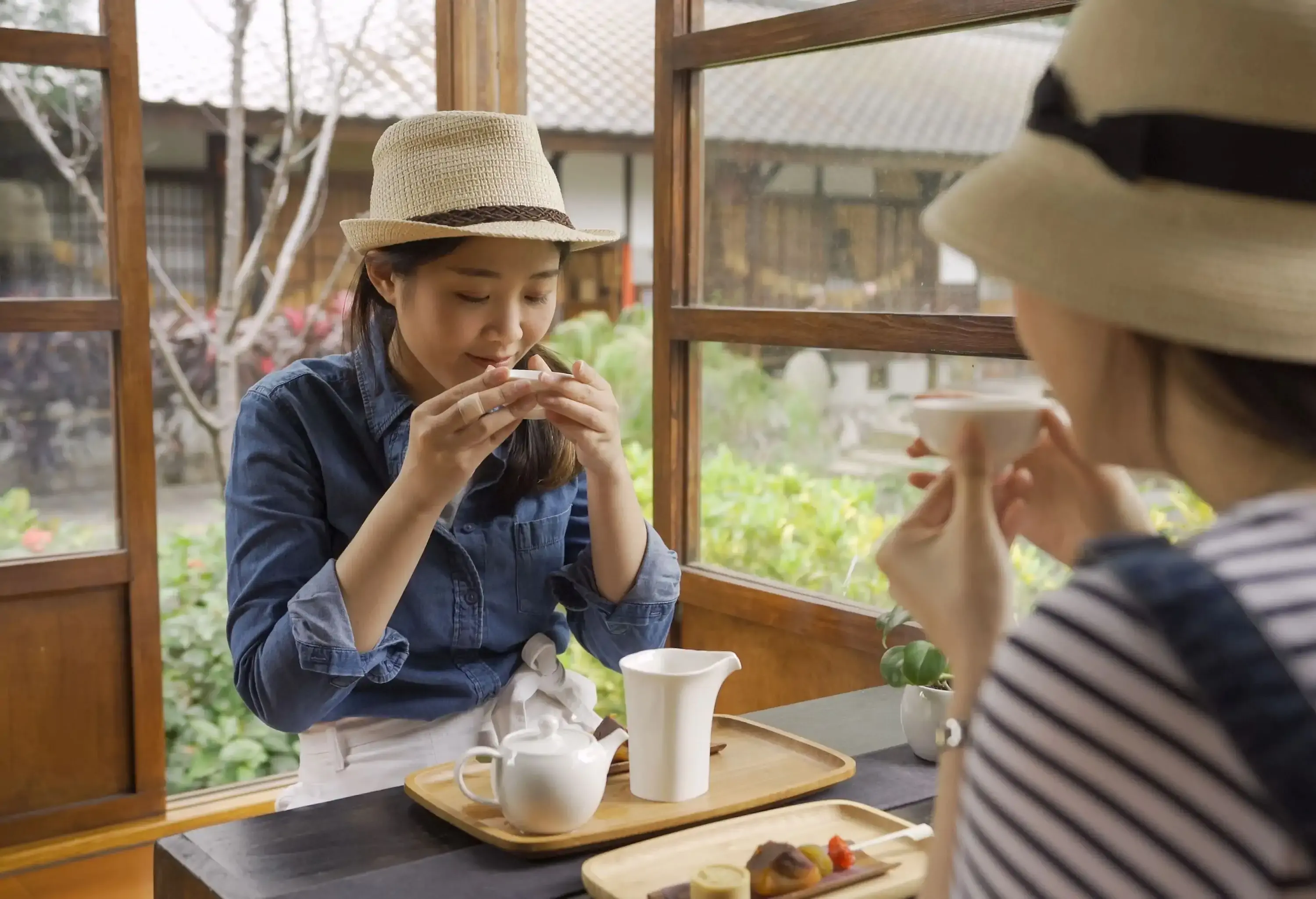 Two young women enjoy tea at a local Japanese cafe.