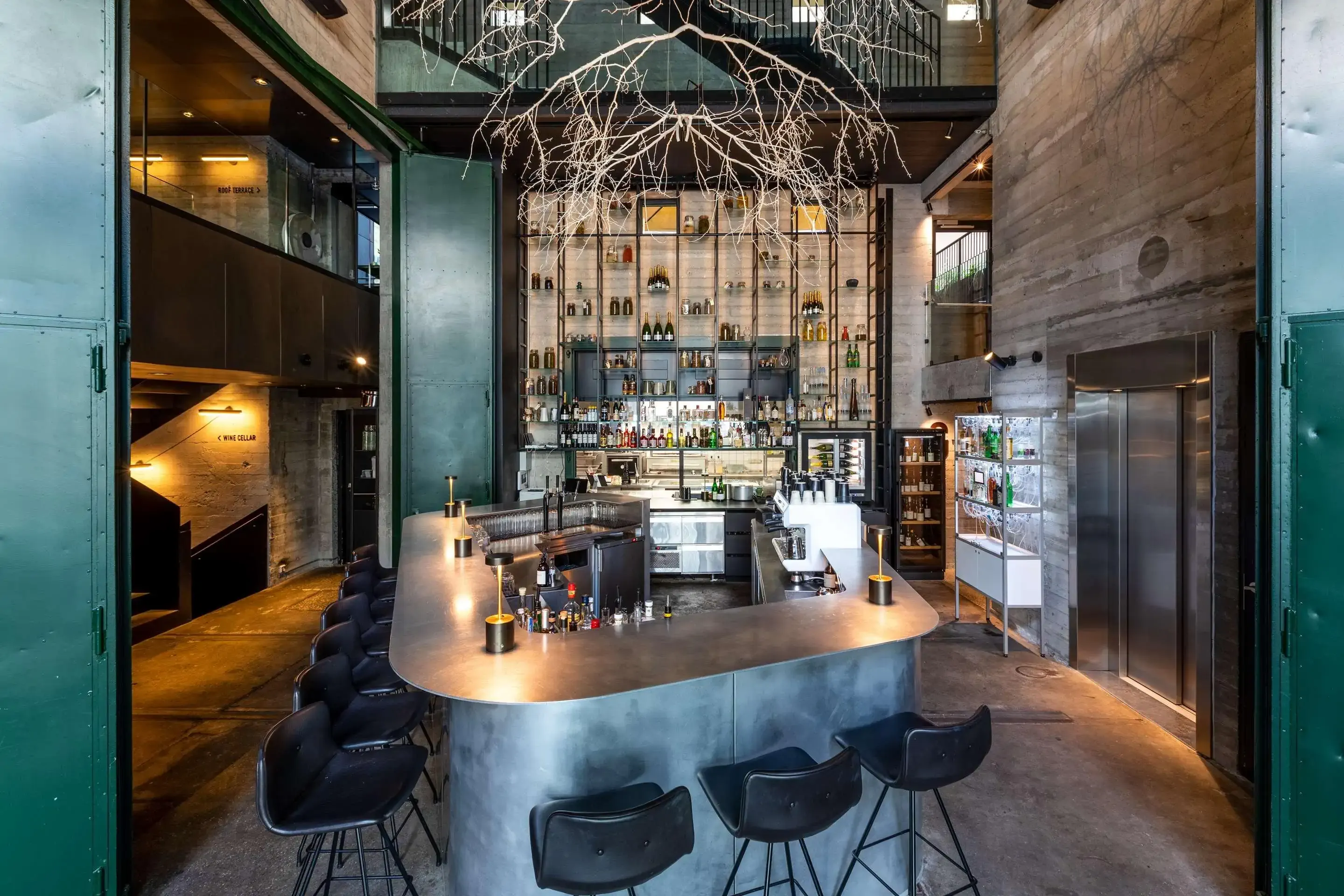 Interior shot of a boutique hotel bar with grey tones and industrial style
