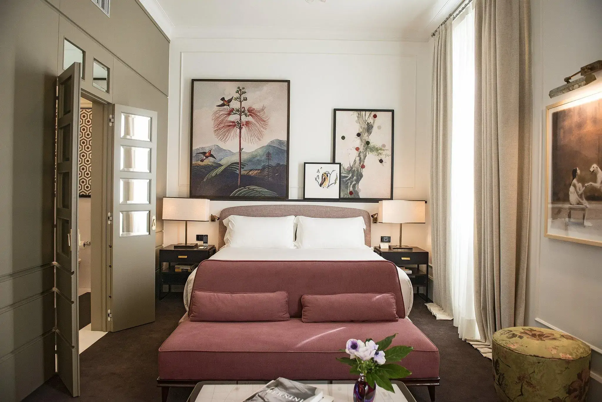Eclectic hotel room with prints arranged above the bed