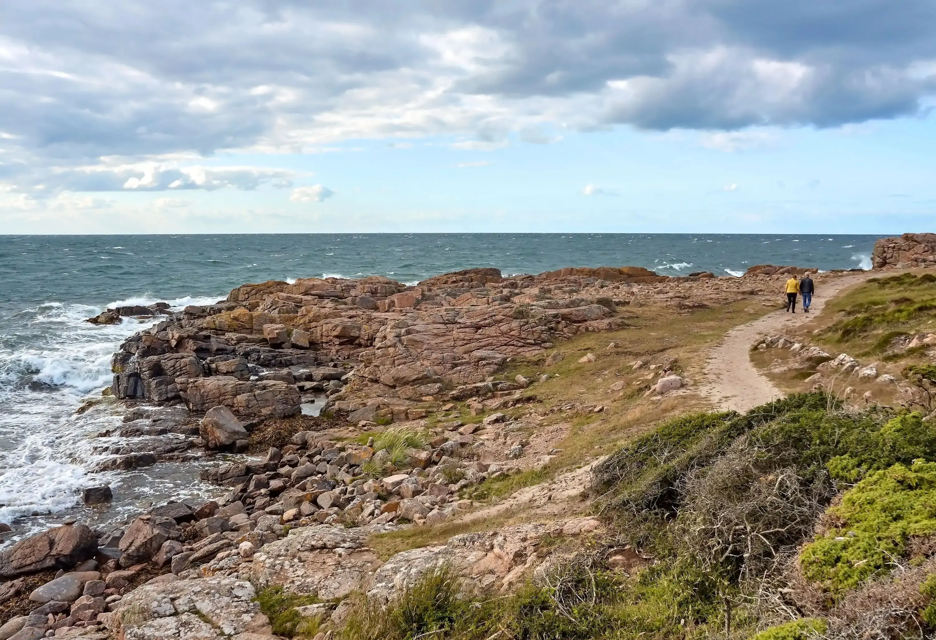 Rear view of a couple having a walk along Baltic Sea coast on a stormy day