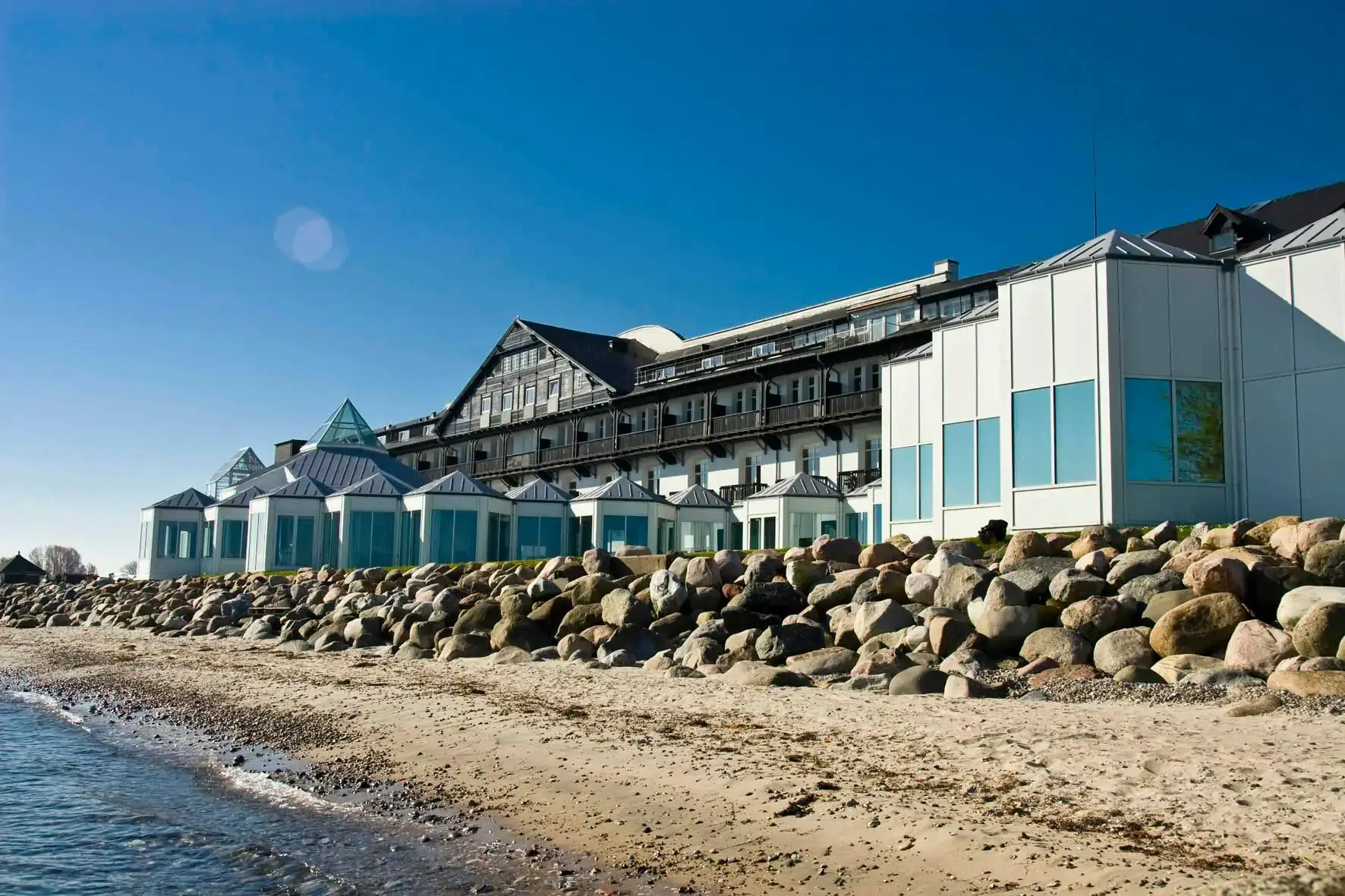 Glass huts on a beach by a hotel