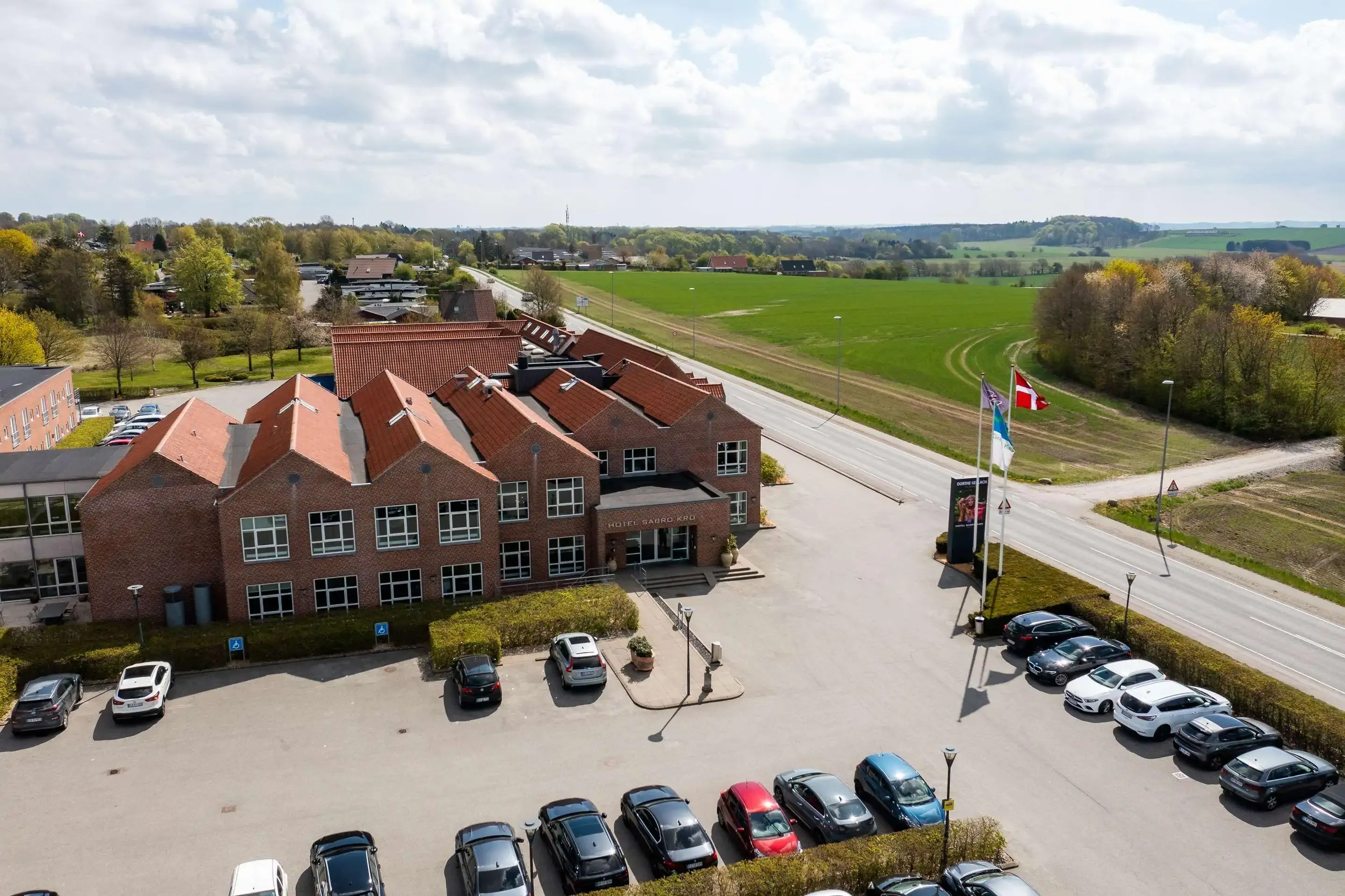 Aerial view of a hotel with adjacent parking on a sunny autumn day