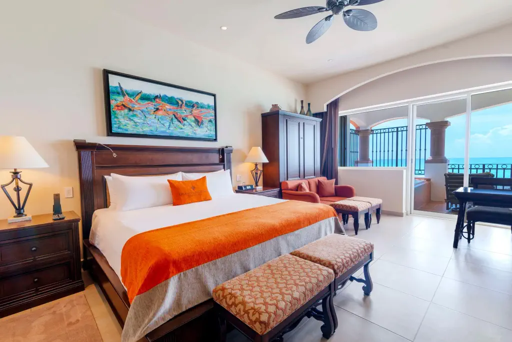 Modern resort hotel room with orange accents and sea view