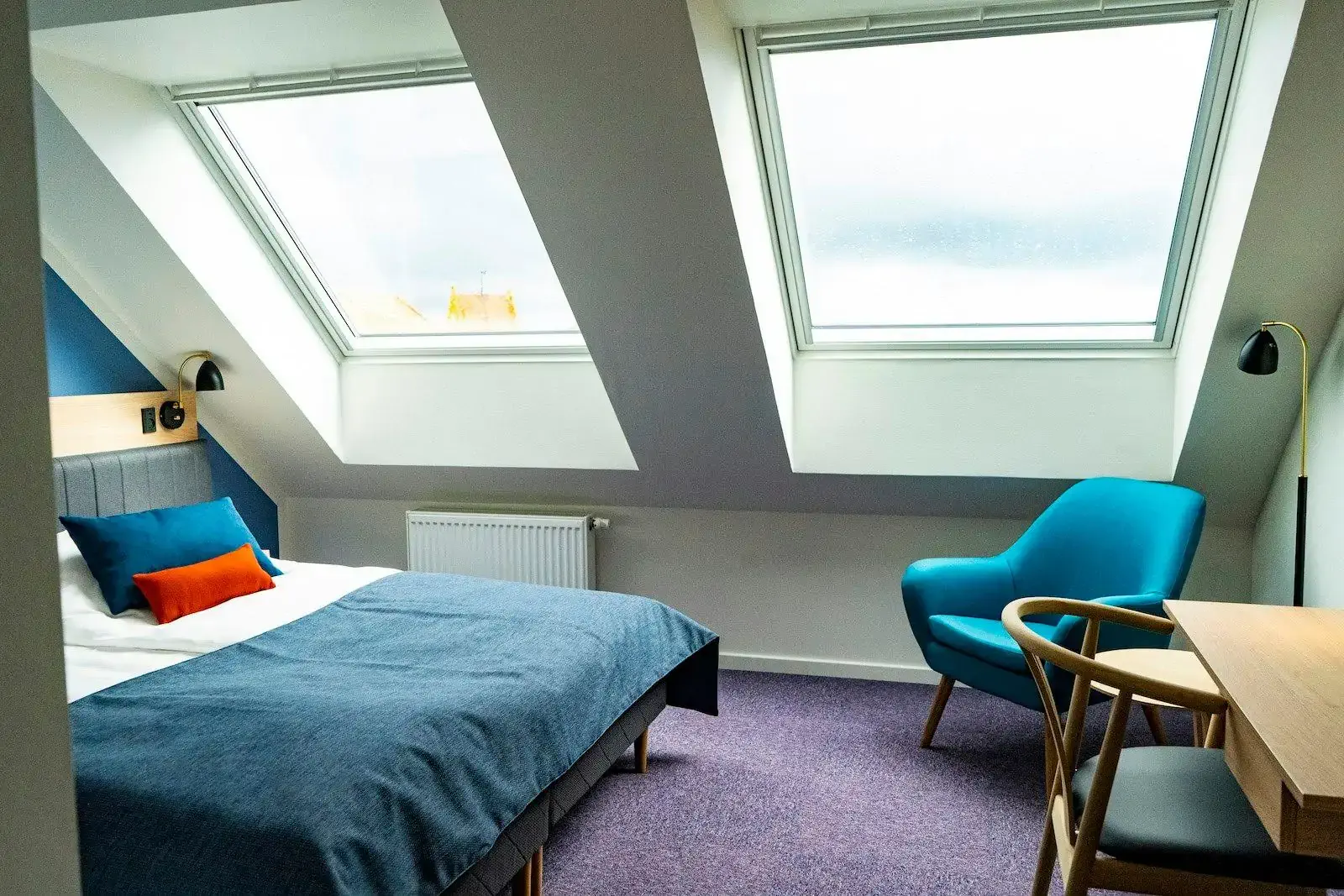 Cozy hotel room in an attic with wool blanket and two windows