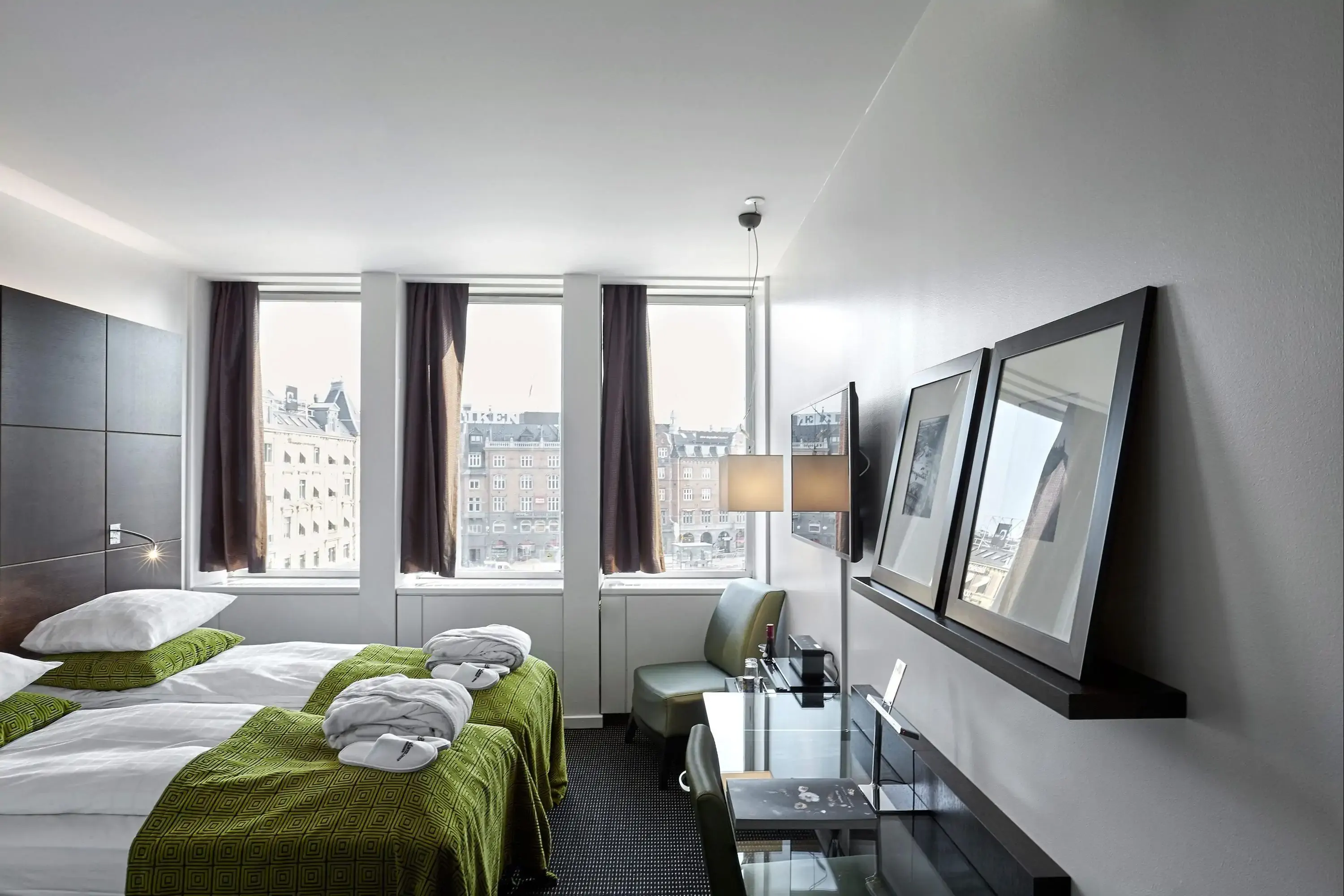 Modern cozy hotel room with green accents and view over a city
