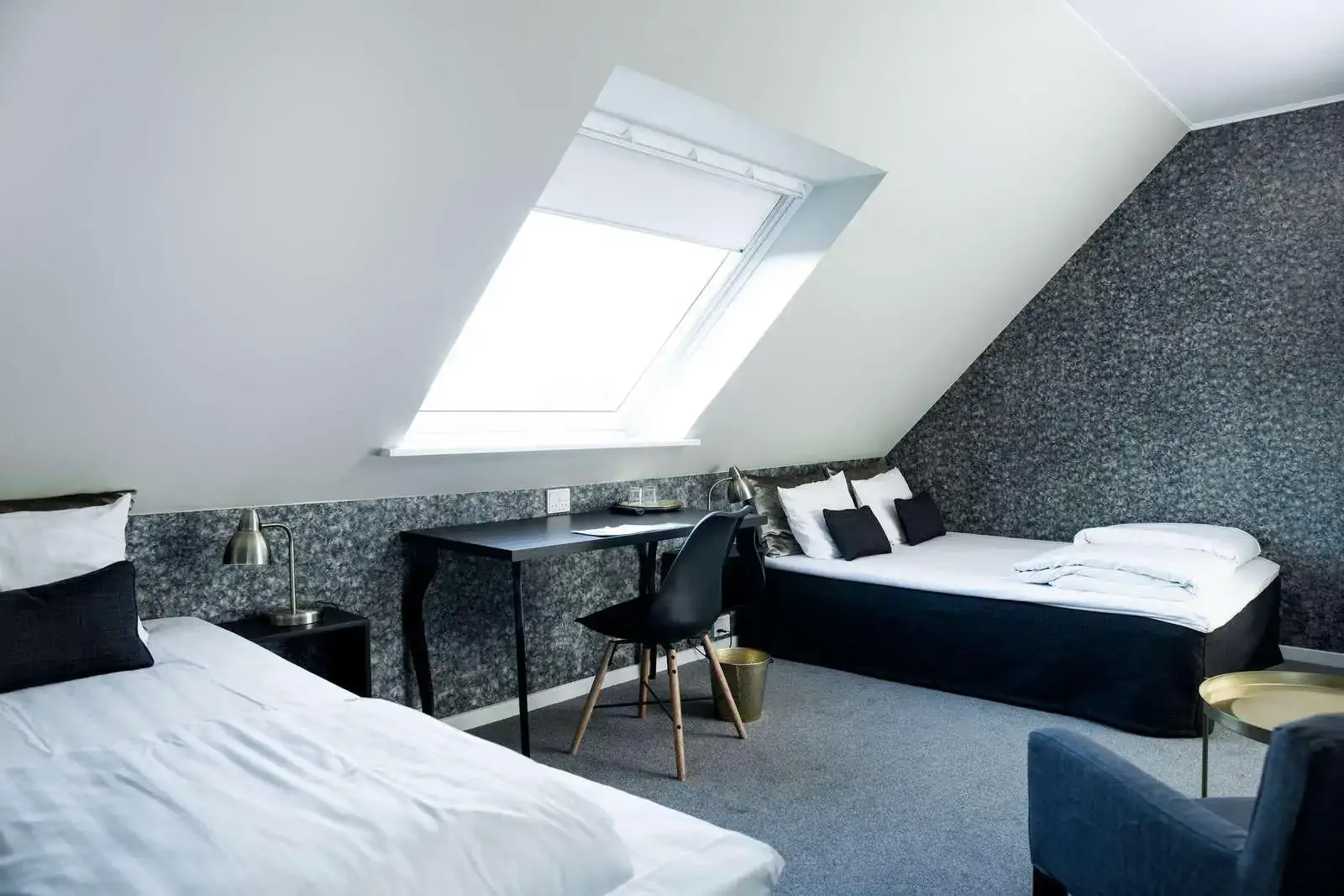 Attic hotel room with skylight and desk by a window