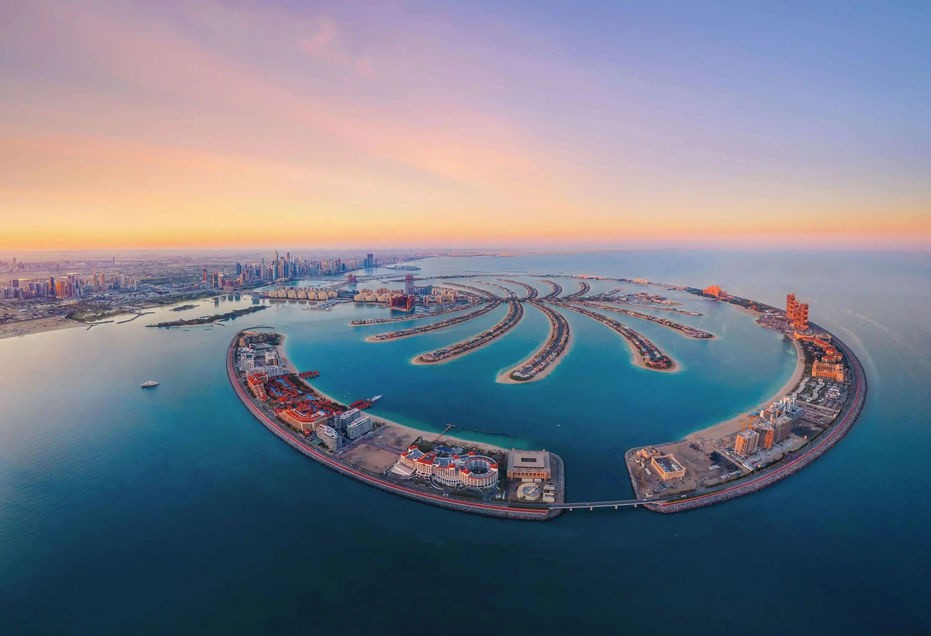 Beautiful aerial view of Dubai's Palm Jumeirah Island against a dramatic twilight sky.