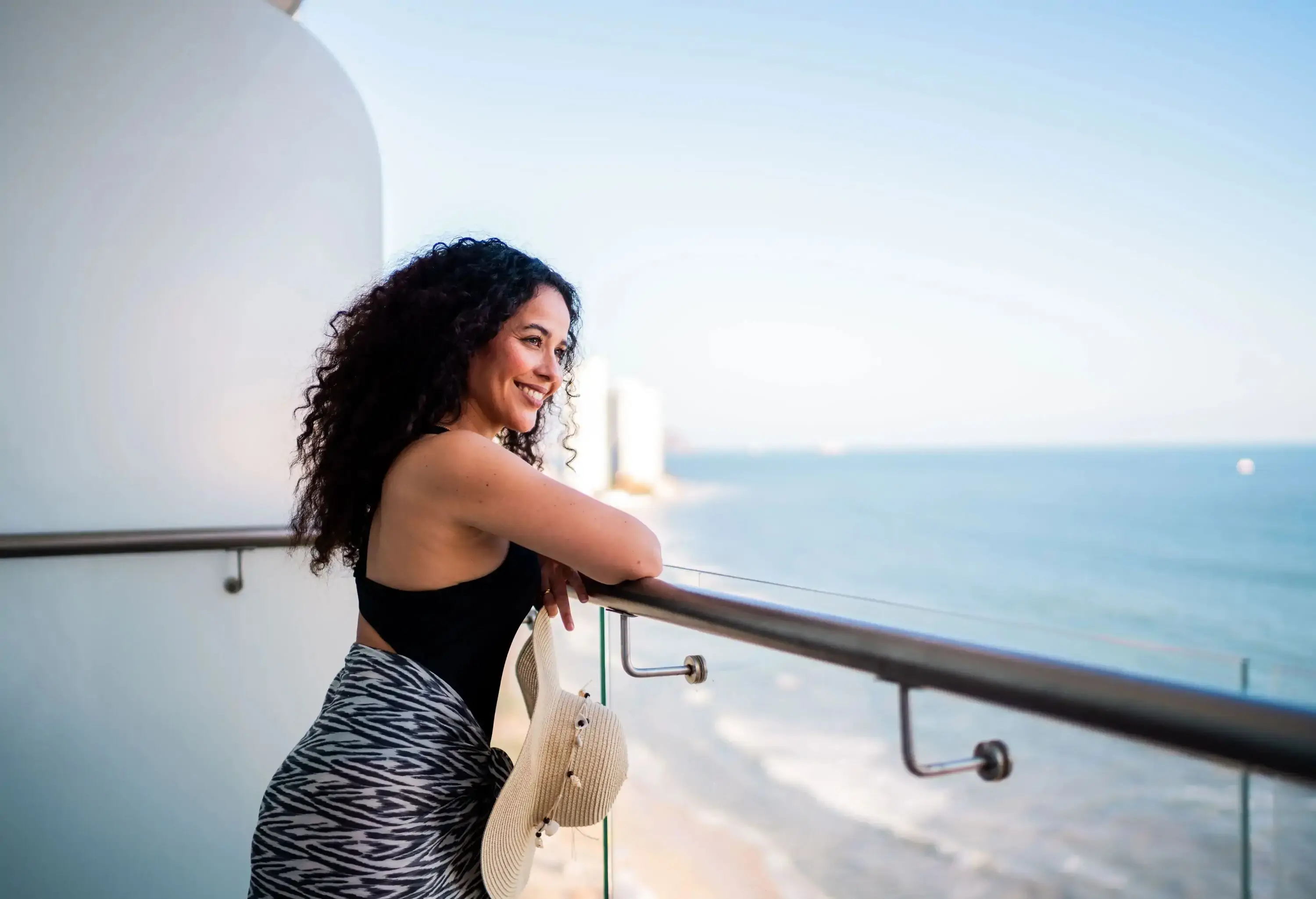 Mid adult tourist woman looking at view on hotel balcony