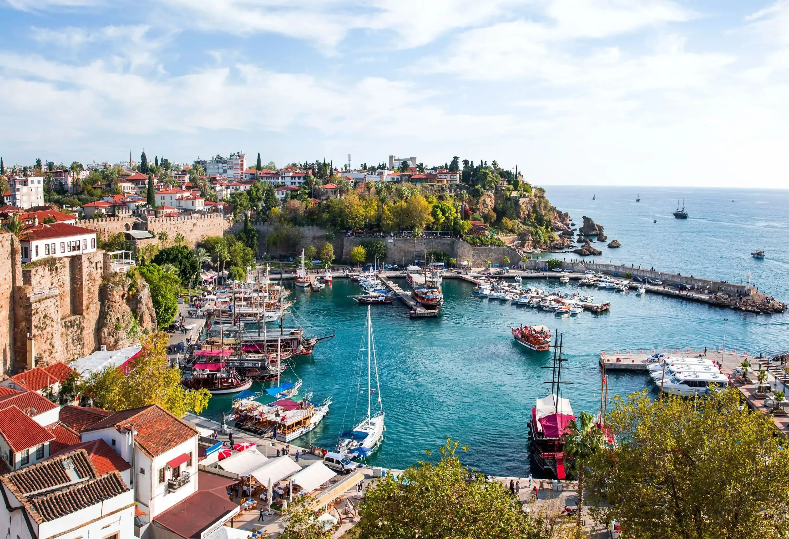 A coastal town with waterfront structures overlooking a marina full of anchored boats.