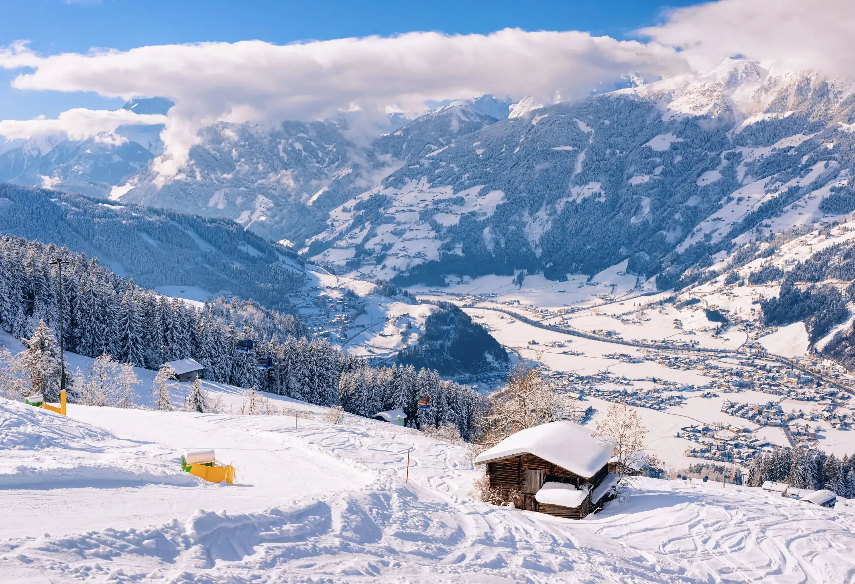 Wooden cottages on the slopes of snow-covered mountains.