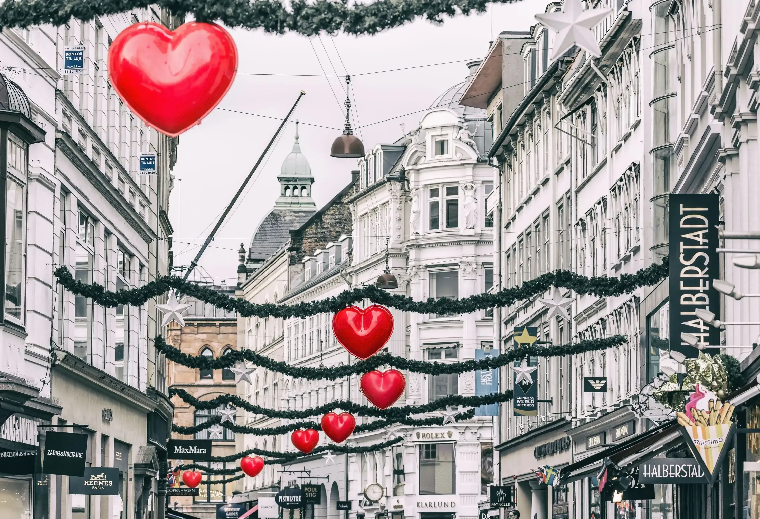 Red, heart-shaped ornaments hanging from garlands over the street.