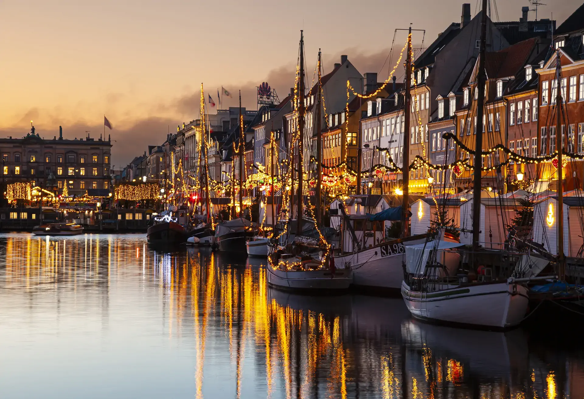 A canal bank with boats decorated for Christmas