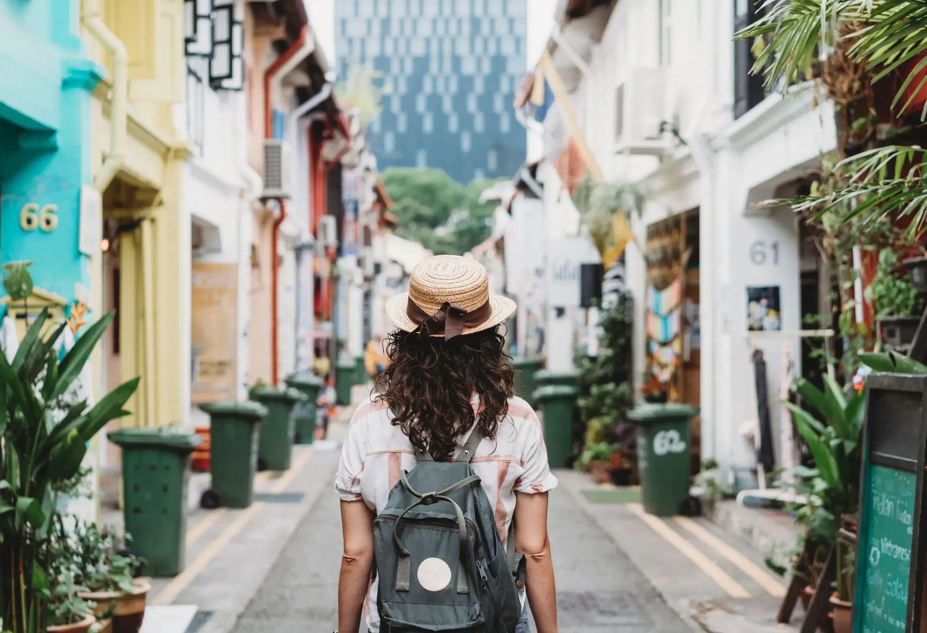 A person standing in the middle of a narrow street between buildings.
