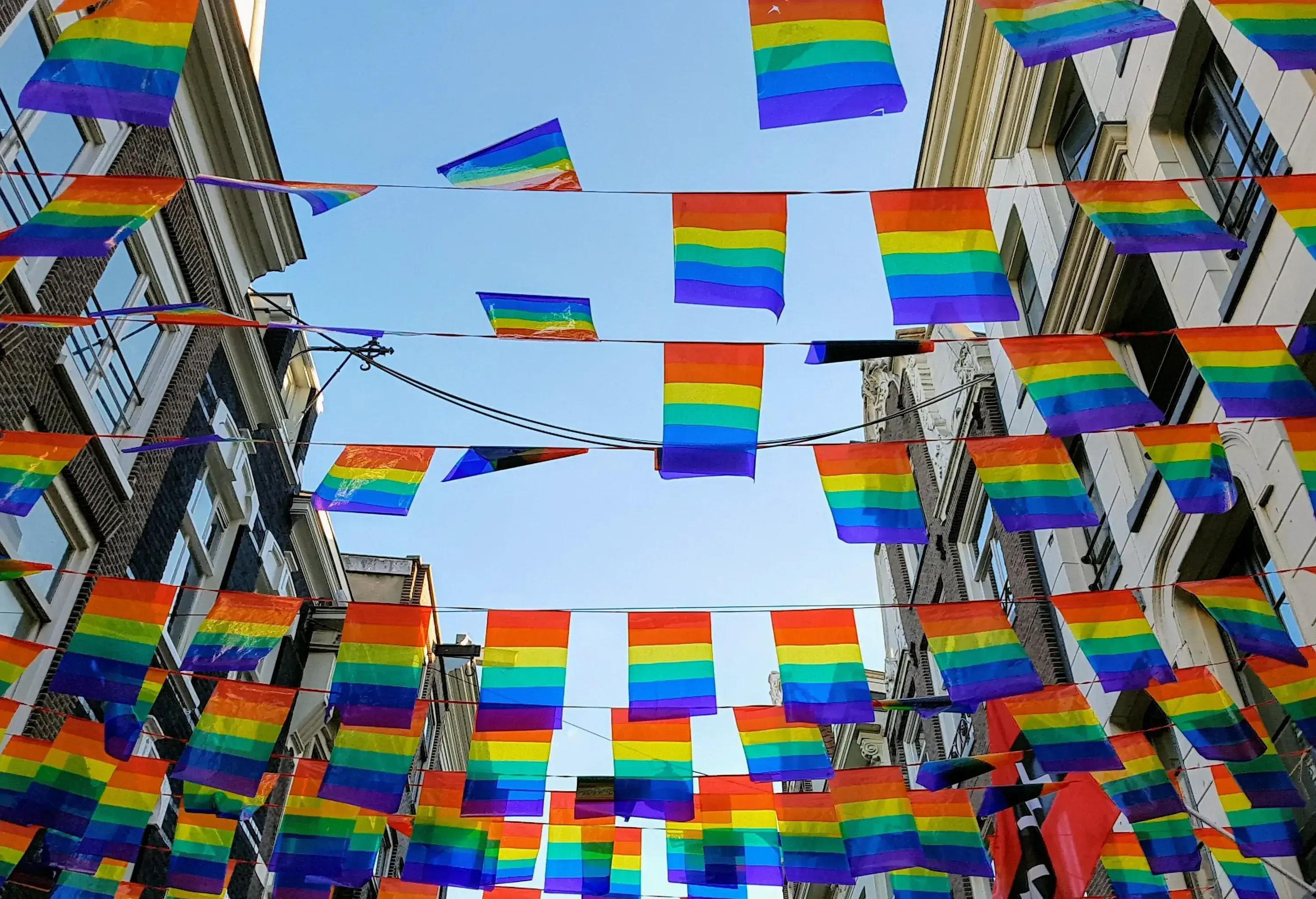 Pride flag banners strung between buildings across the street.