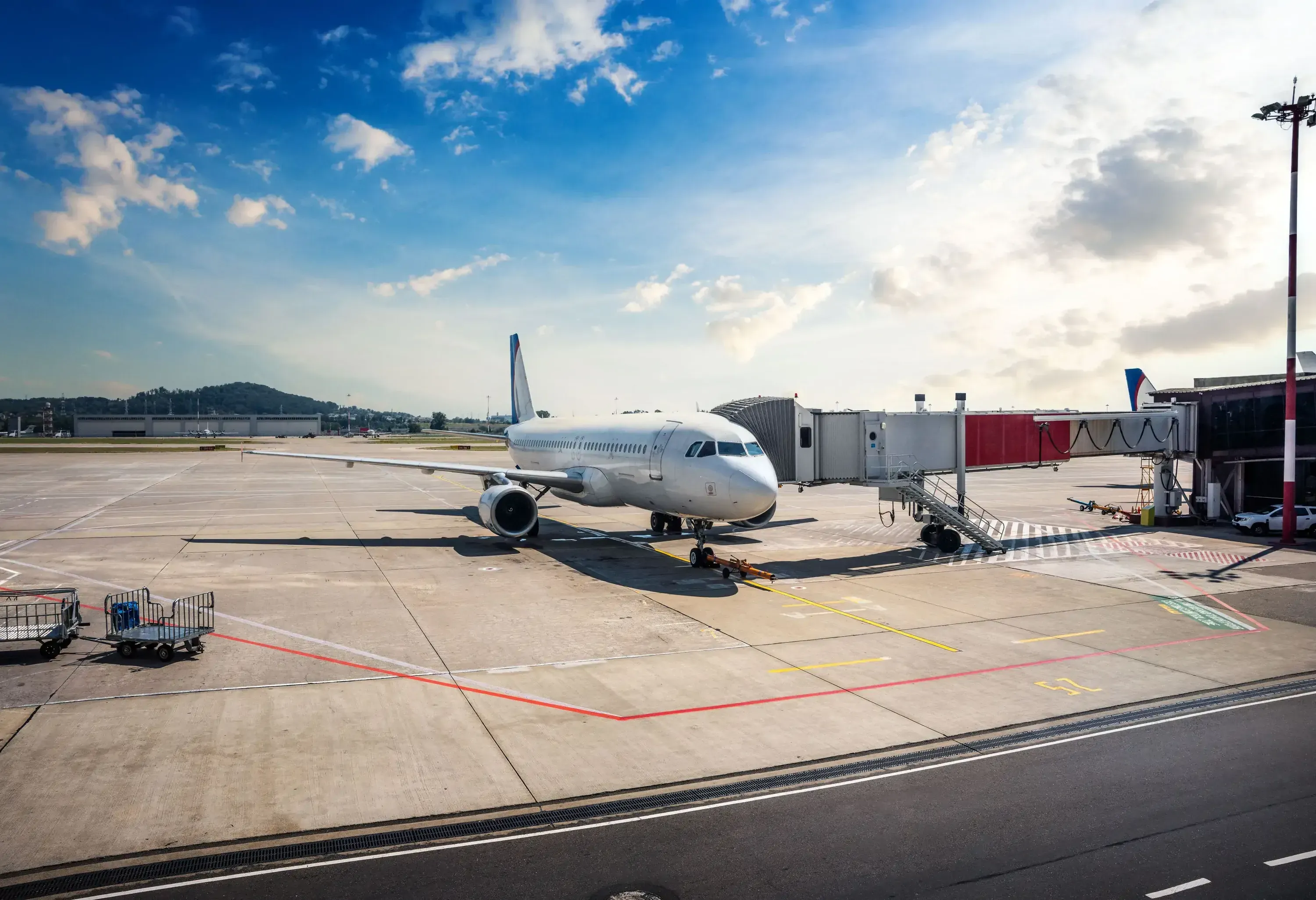 Passenger airplane on the airfield docked with a passenger boarding bridge. Aircraft preparation to departure.