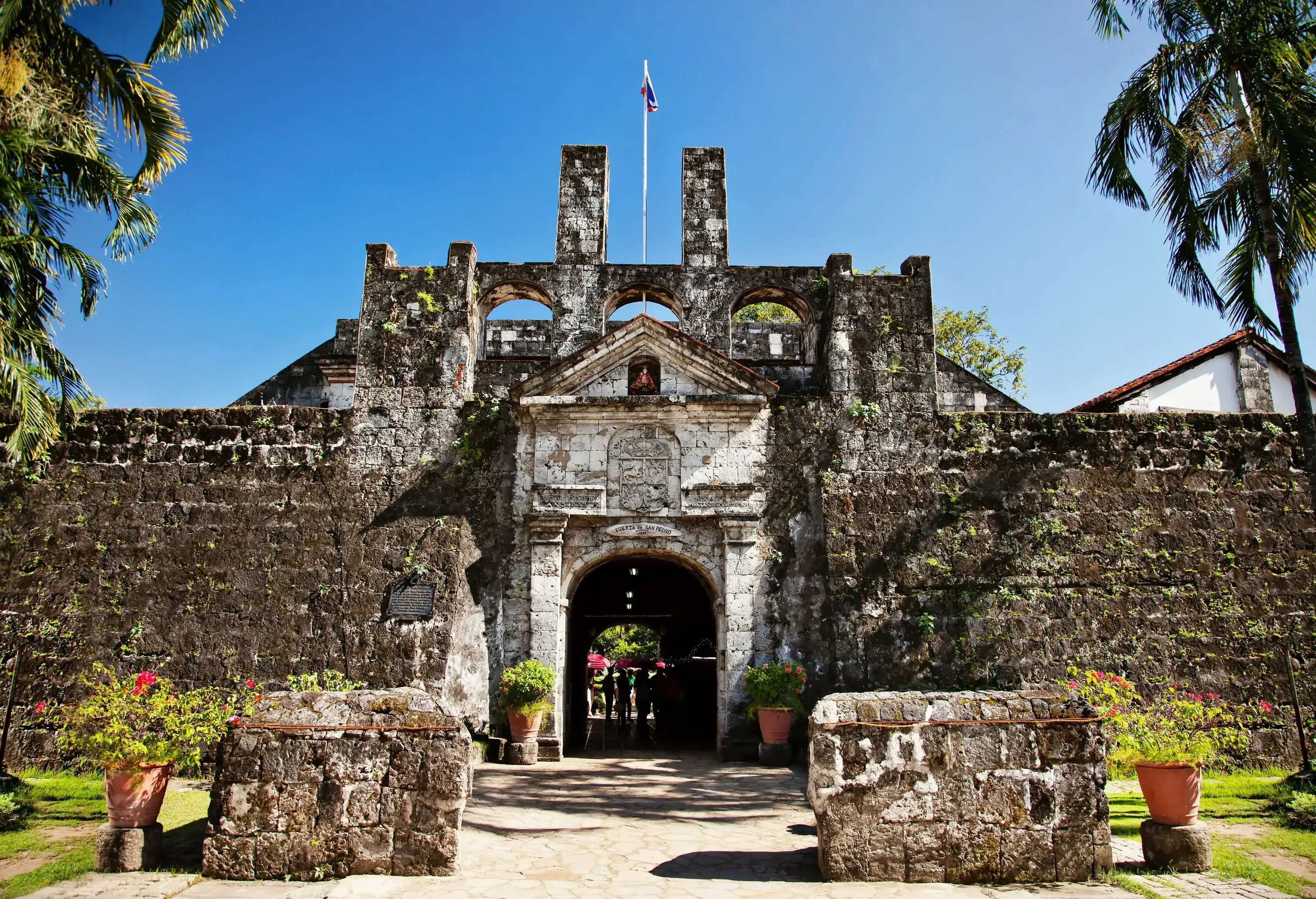 The weathered archway of Fort San Pedro in Cebu, showcasing its old brick facade with charming water stains.