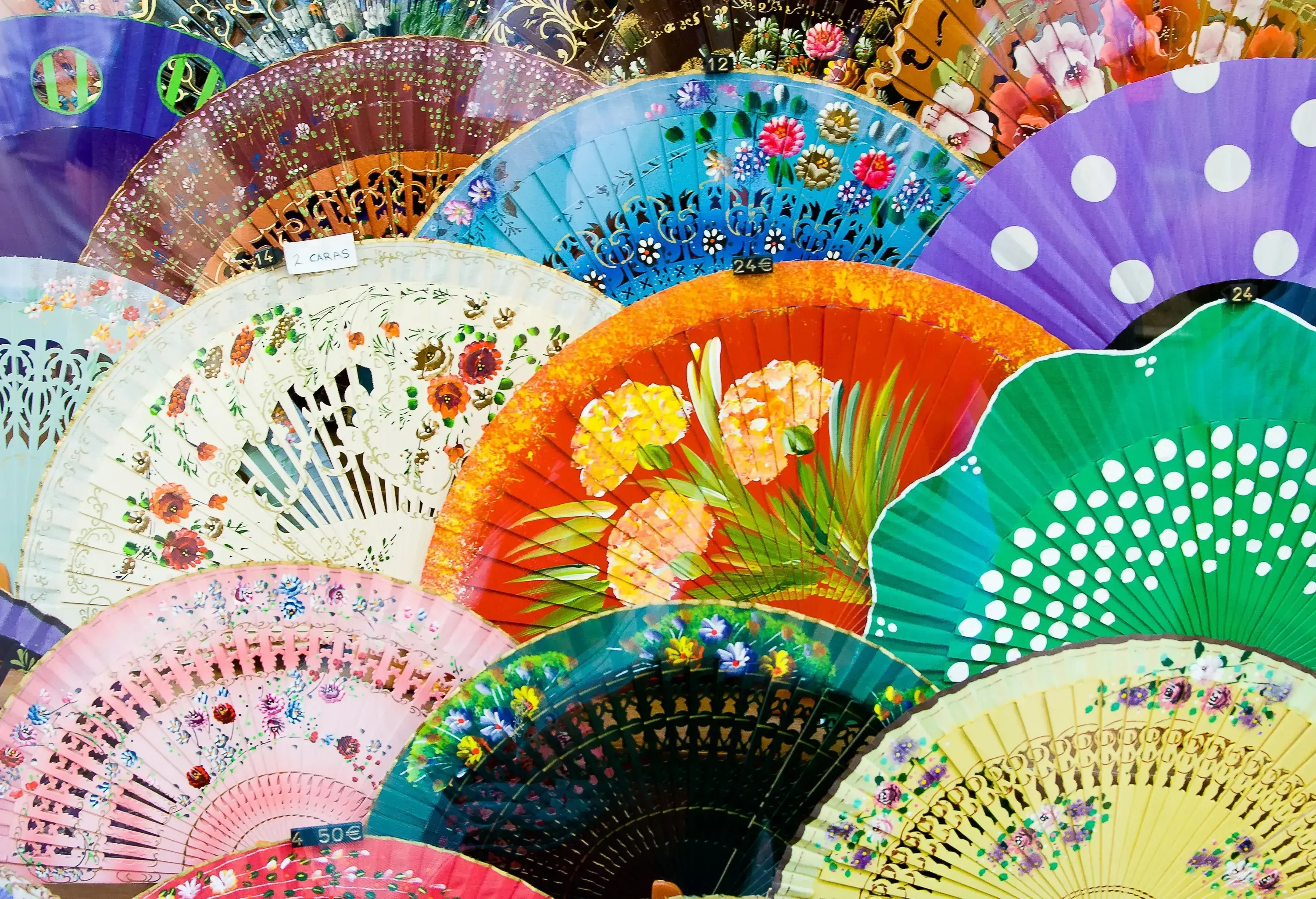 Open folding fans with floral and polka dot patterns.