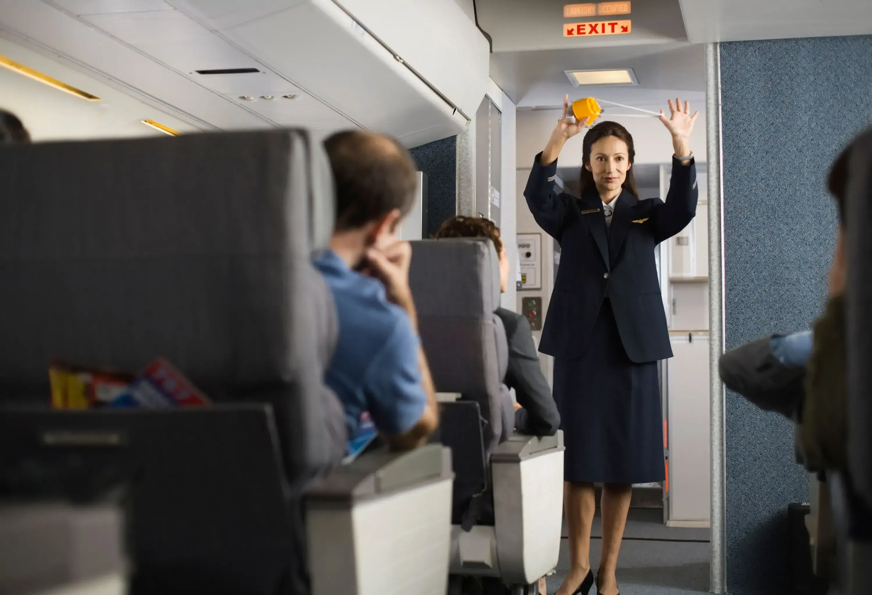 Flight attendant giving safety guidelines on the plane.