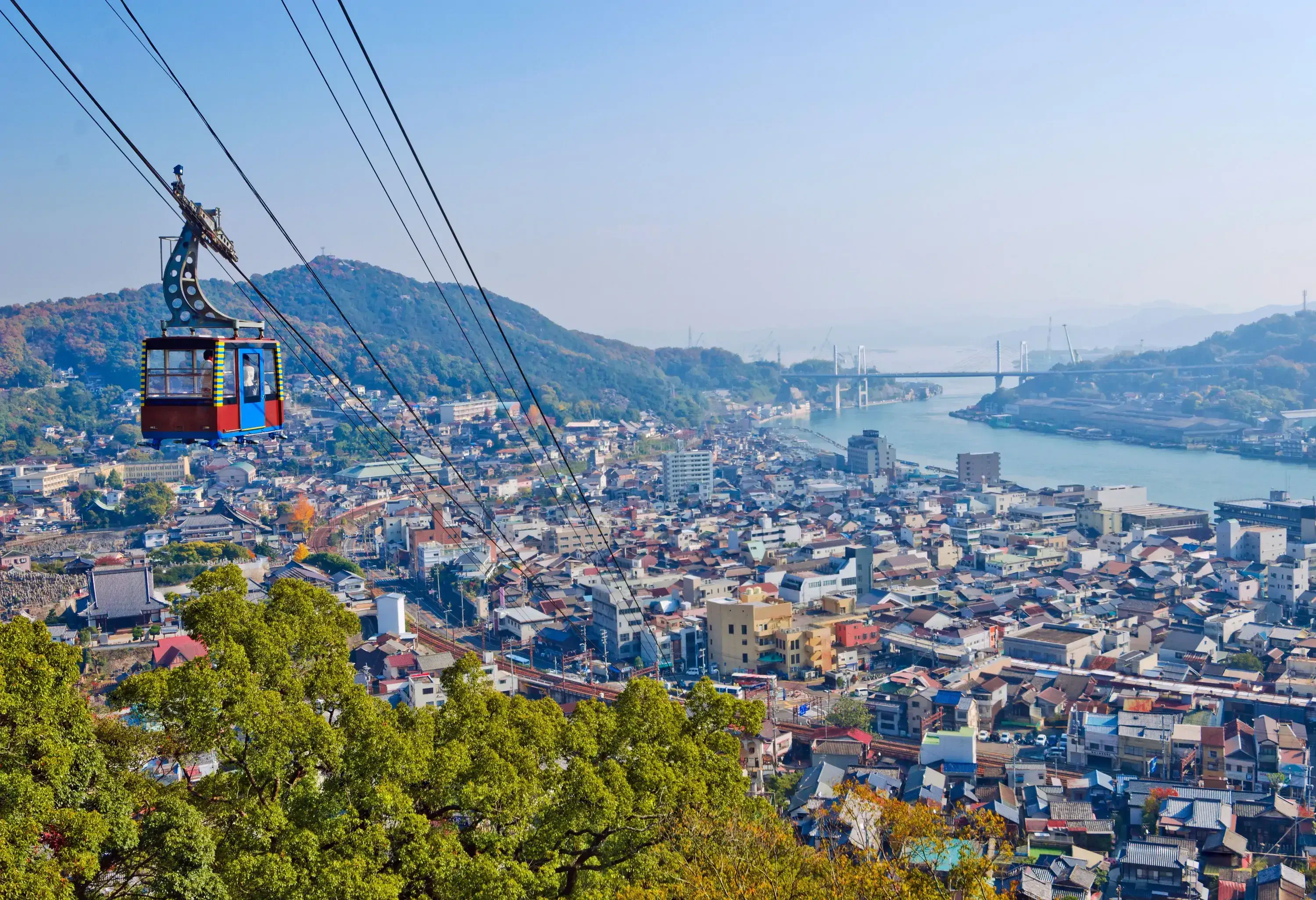 A cable car gliding above a populous city.