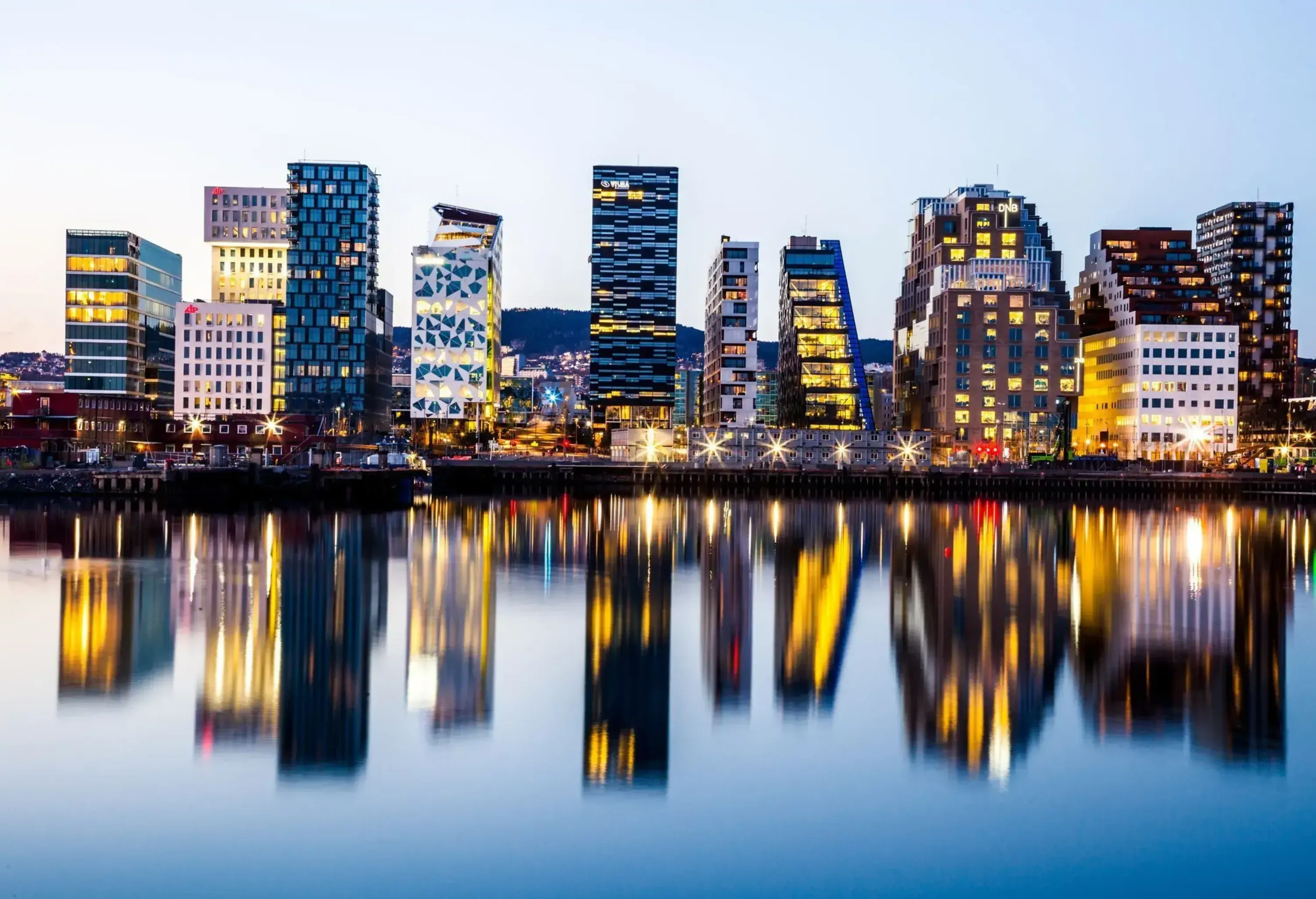 Oslo modern skyline. Several buildings built on the water's edge in the Norwegian capital city. Reflections on the water.